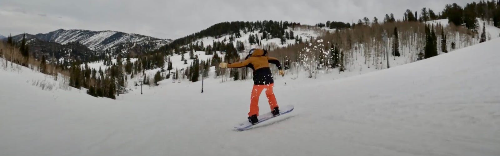 Snowboard Expert Sydney Johnson jumping with the Roxy XOXO Pro snowboard on a groomed run