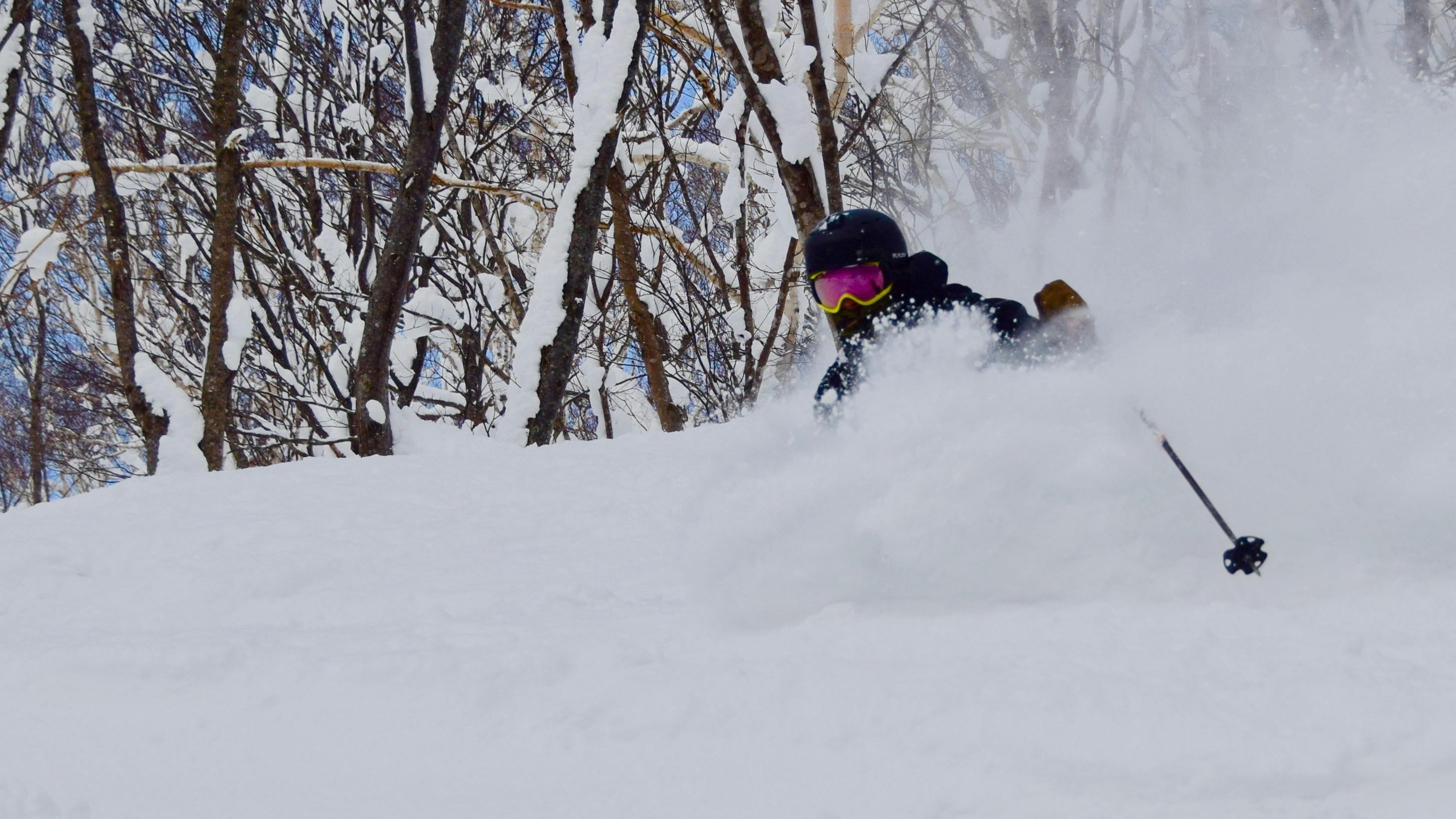 A skier skis through a huge pile of powder