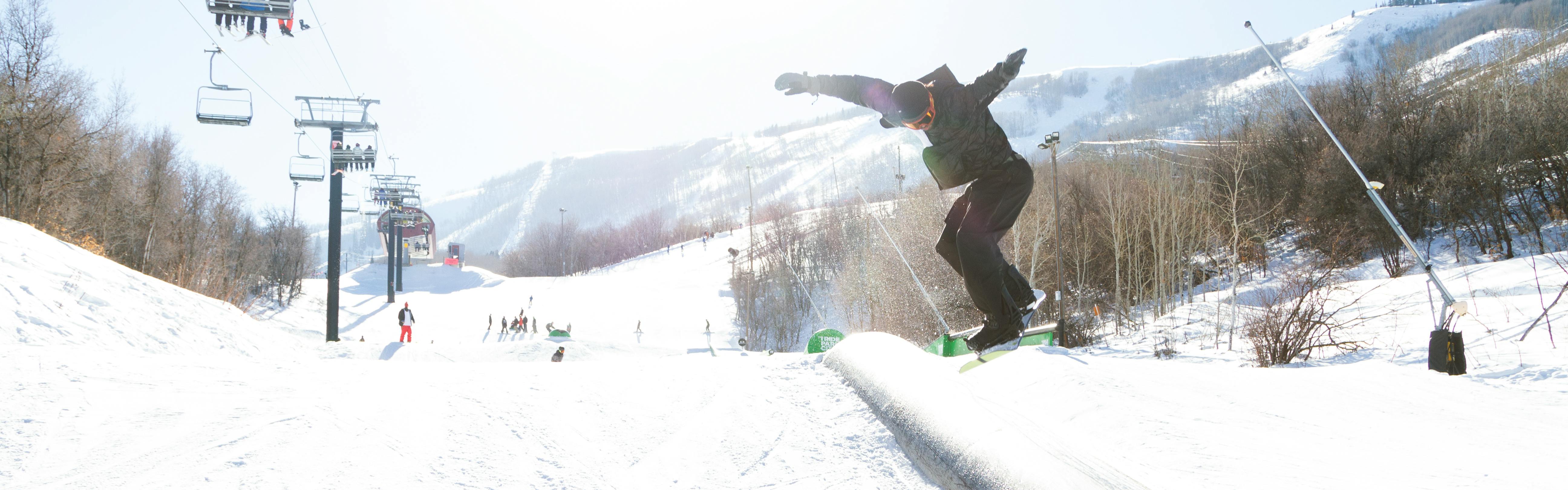 A snowboarder hitting a feature. 