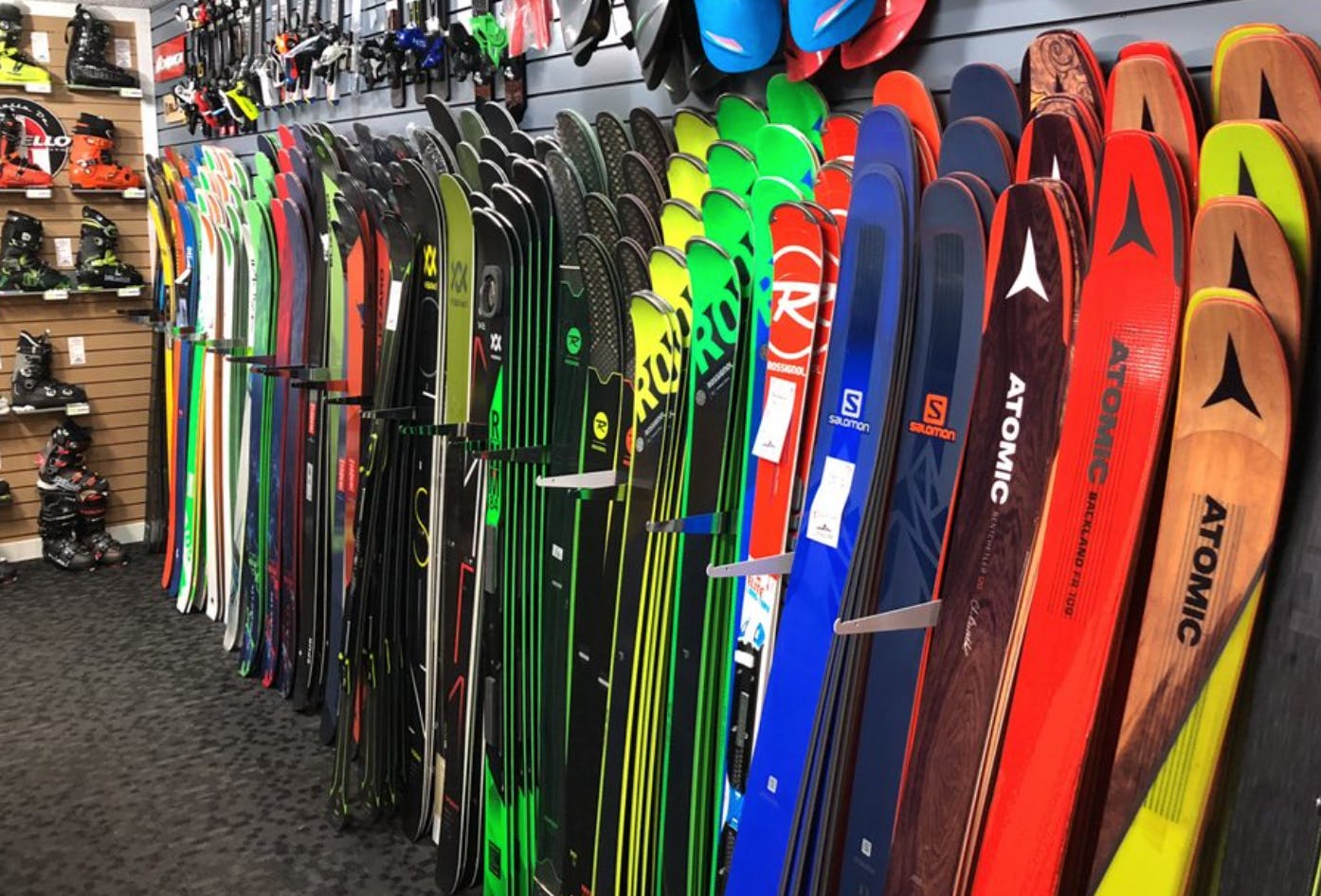Skis along a wall in a ski shop. 