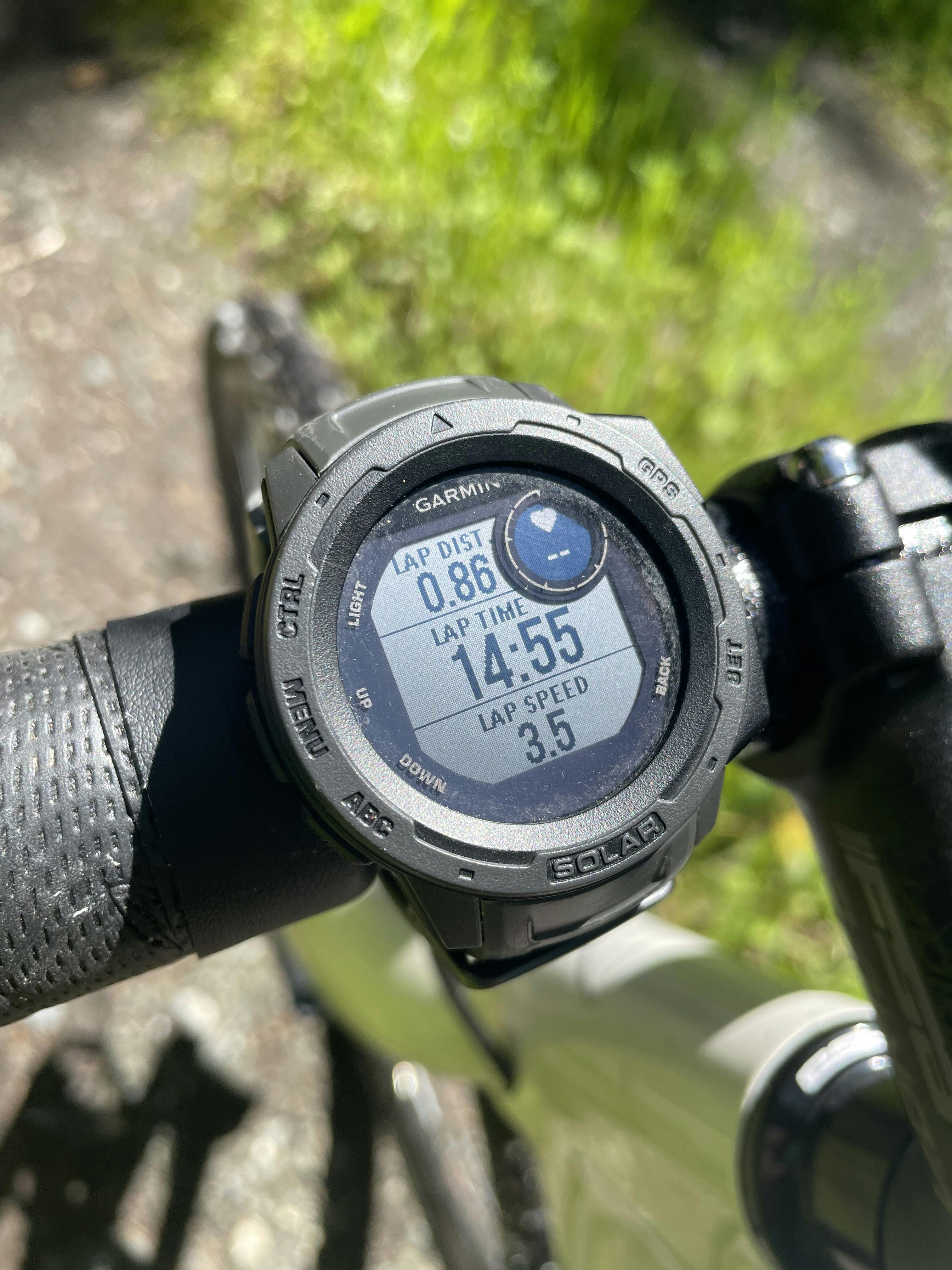 A Garmin watch attached to bike handlbars.