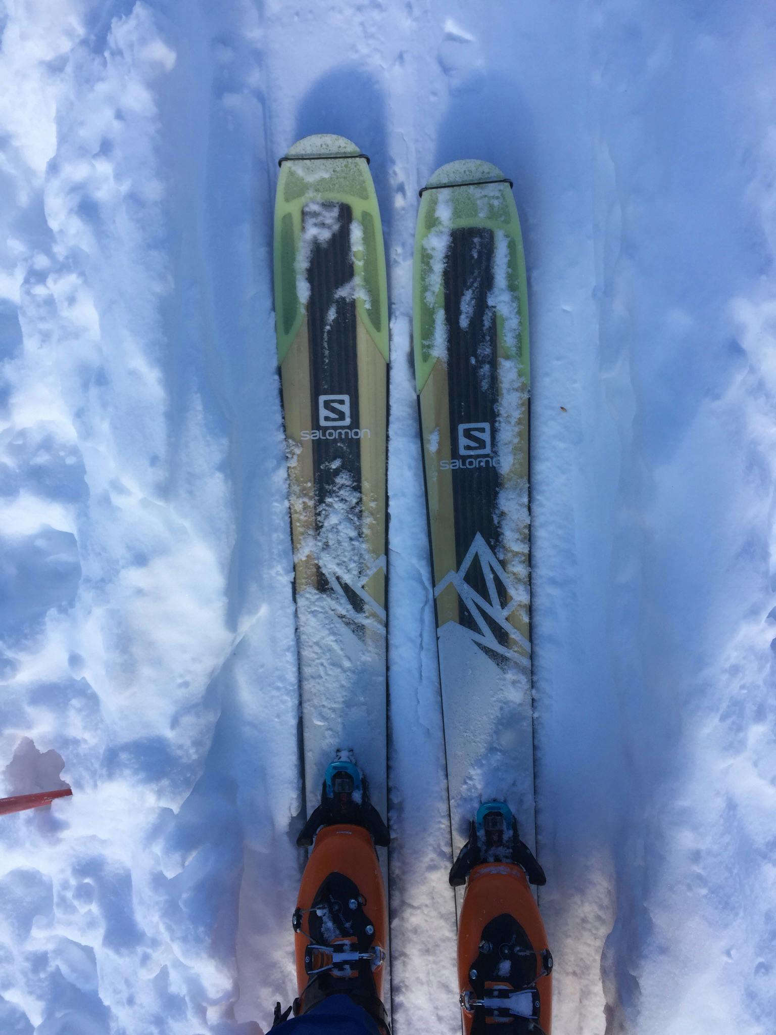 Top down view of the Salomon QST 106 skis mounted with Atomic Shift Bindings. 
