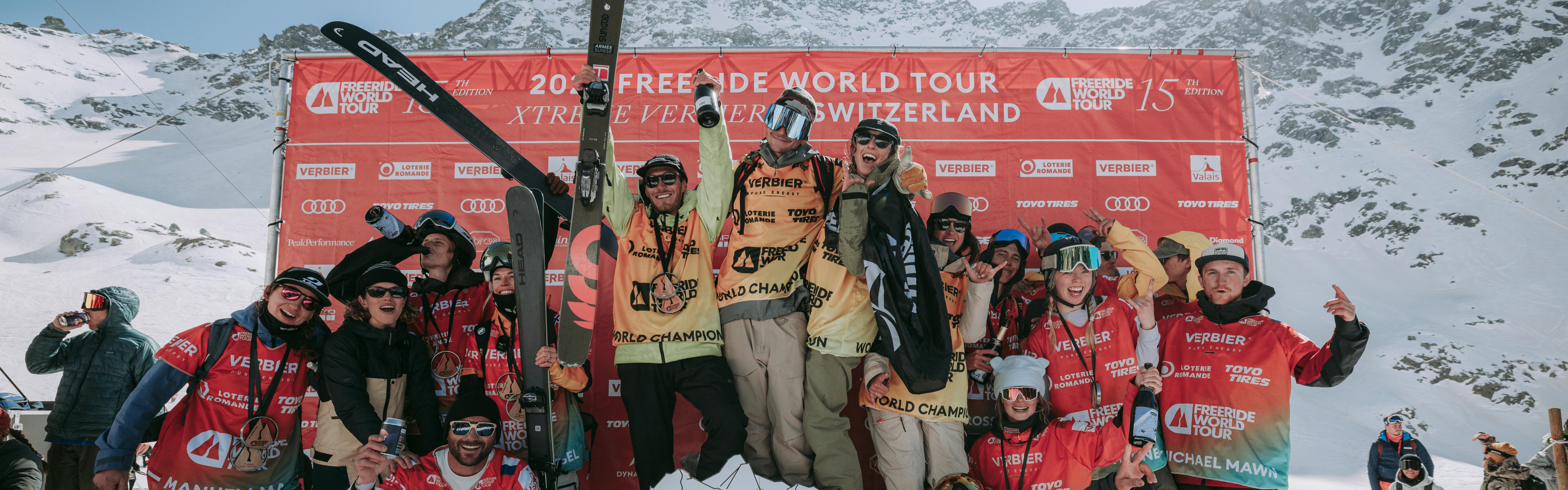 All the winners and athletes from Stop Five of the Freeride World Tour crowd on the podium and smile for the camera.
