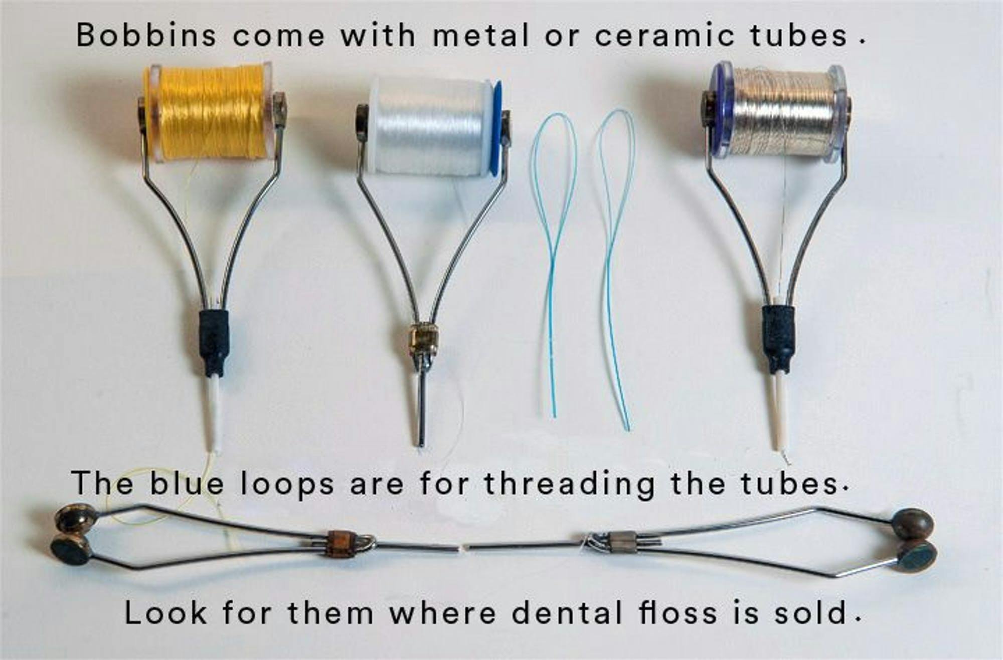 An image of five bobbins and two dental floss threaders on a white background. The text reads "Bobbins come with metal or ceramic tubes. The blue loops are for threading the tubes. Look for them where dental floss is sold."