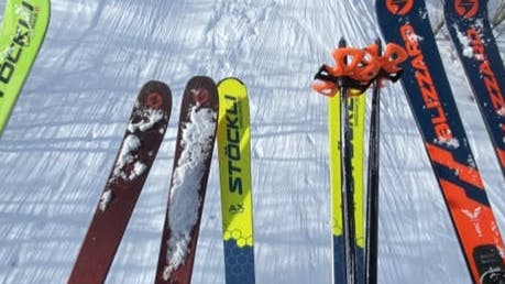 Top down view of three pairs of skis on a chairlift.