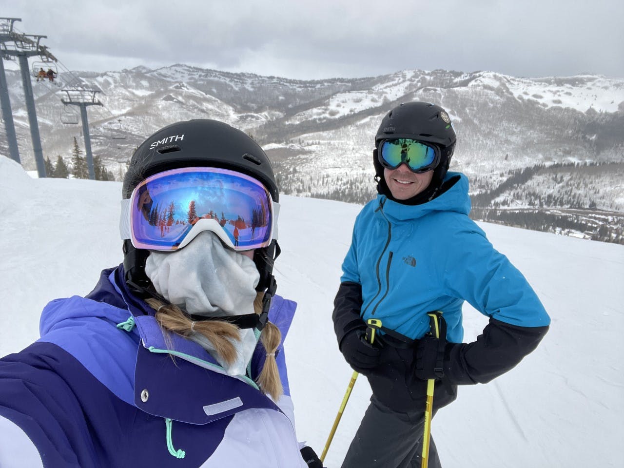 Two skiers on a run at a ski resort. 