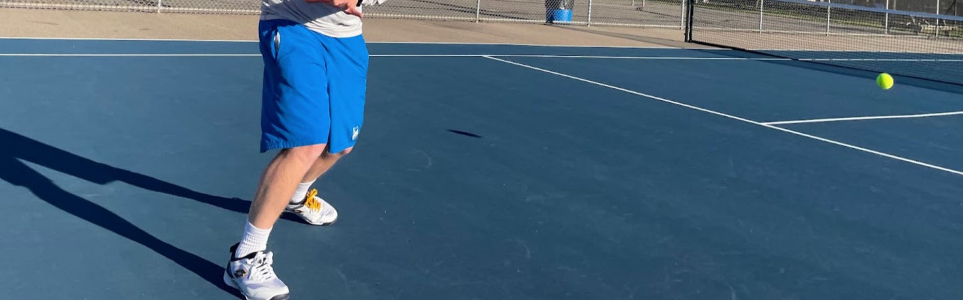A tennis player using the Lotto Mirage 200 Speed Shoes.