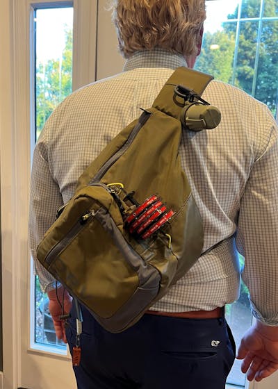 A man wearing the Orvis Sling Pack.