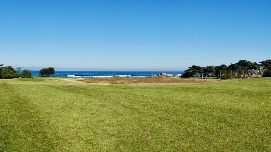 A green course and ocean beyond