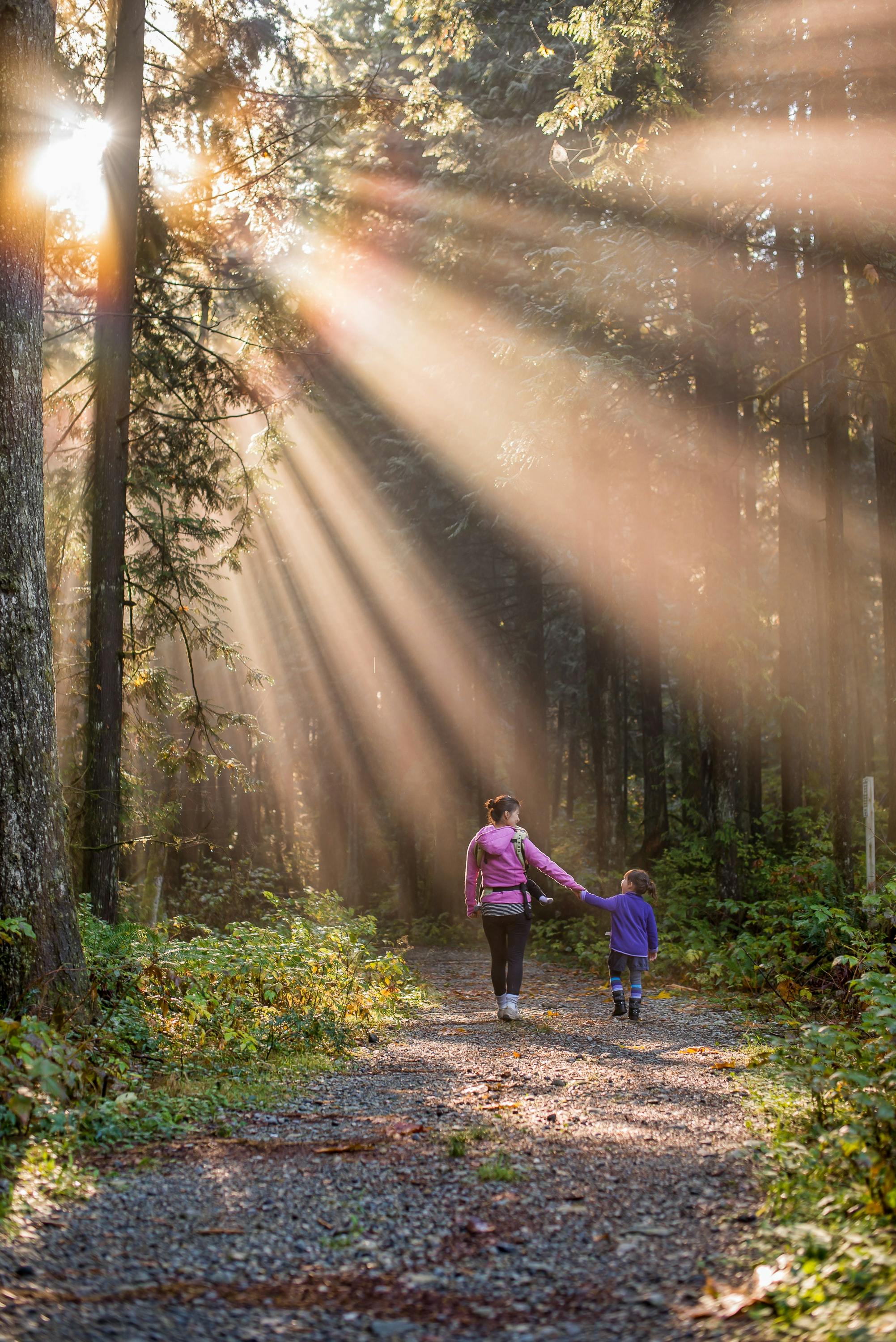 A mom and child walking on a hiking trail. 