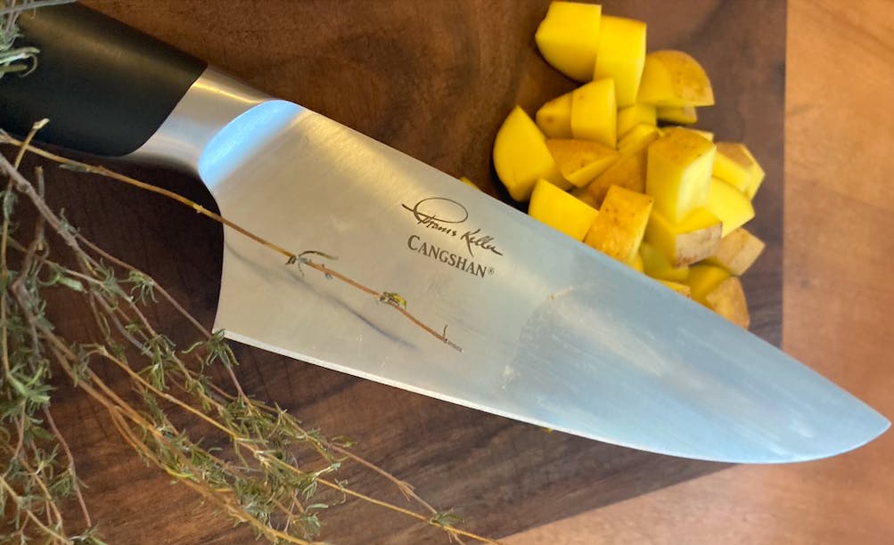 The Cangshan Thomas Keller Signature Collection Chef's Knife, 8" next to some potatoes. 