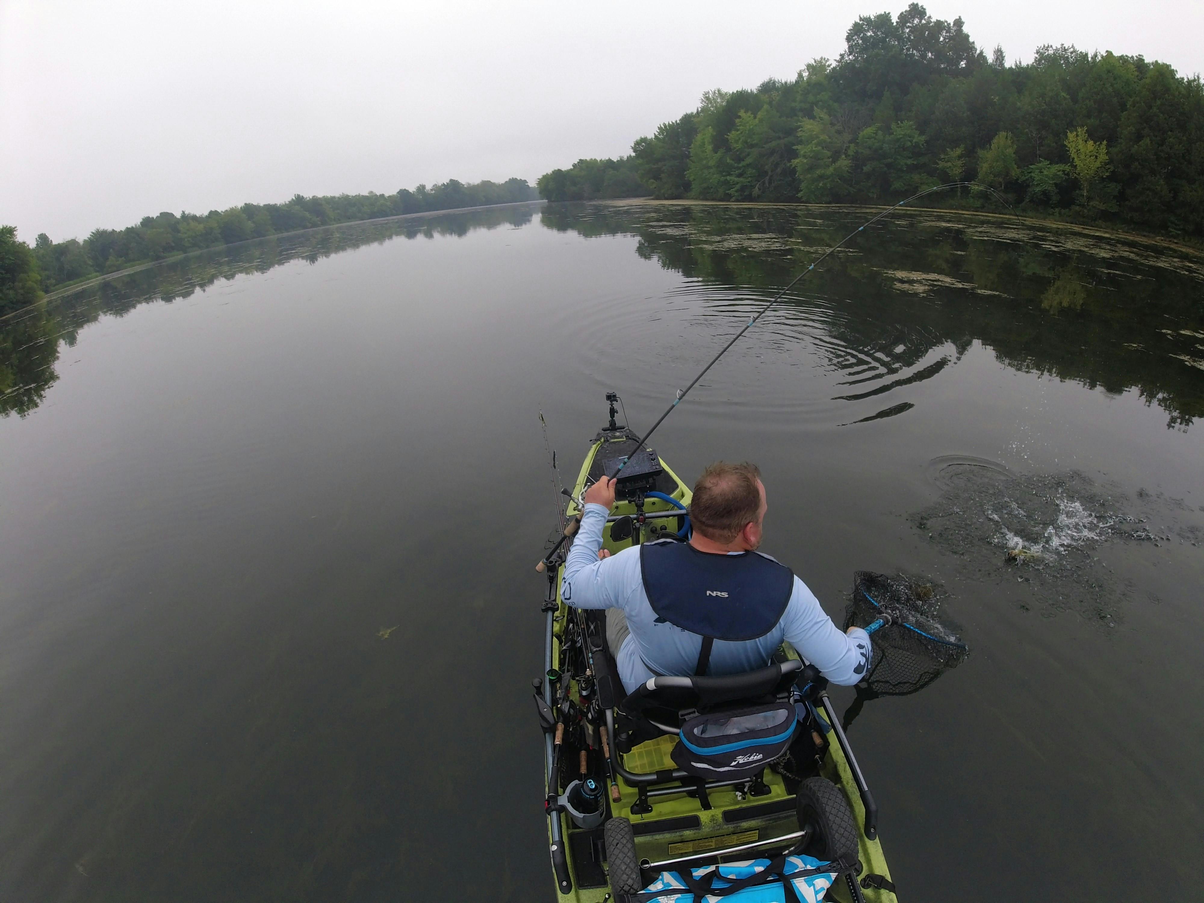 A man in a kayak on a river using the Shimano Stradic FL Spinning Reel.