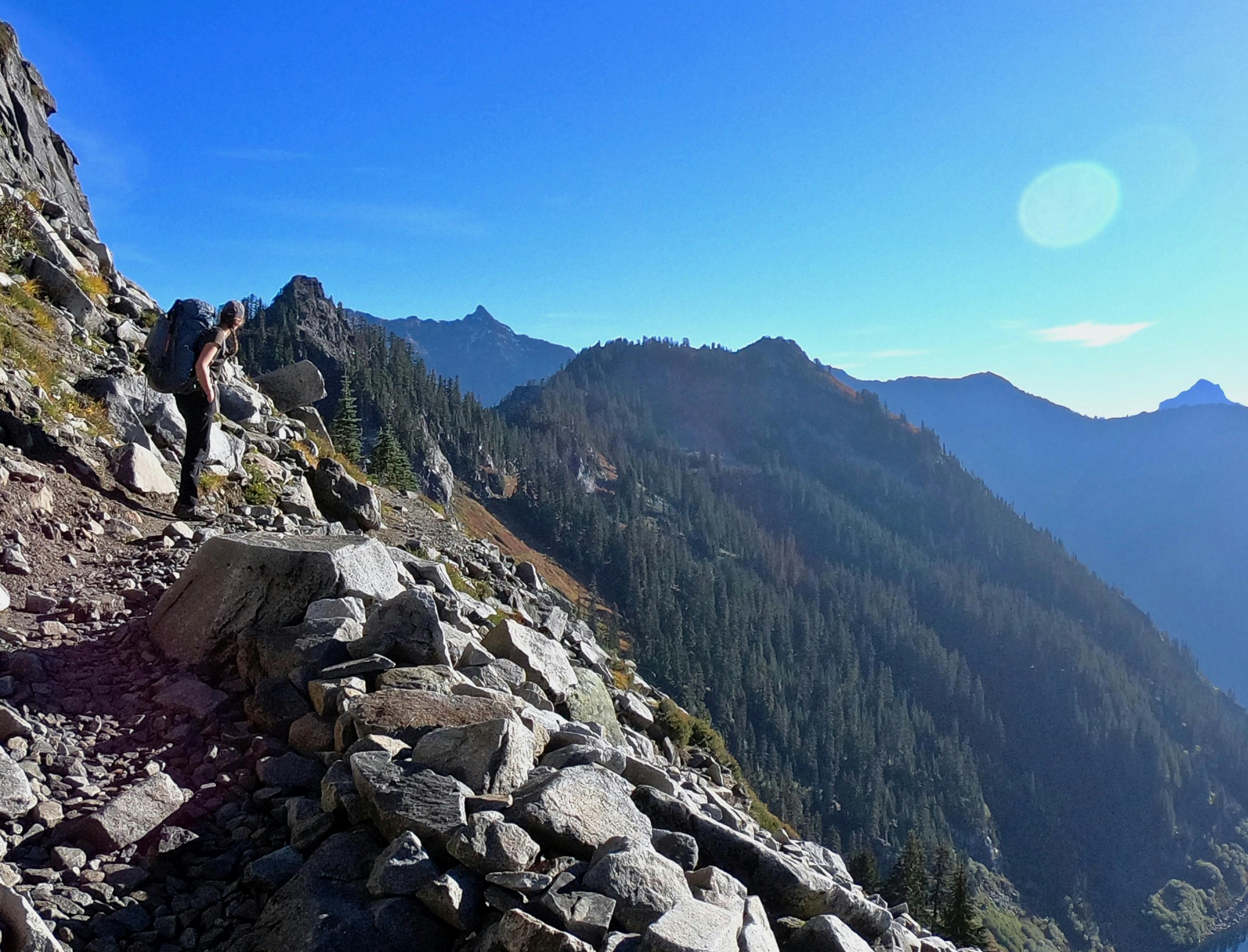 A woman looks ahead on a rocky hiking trail
