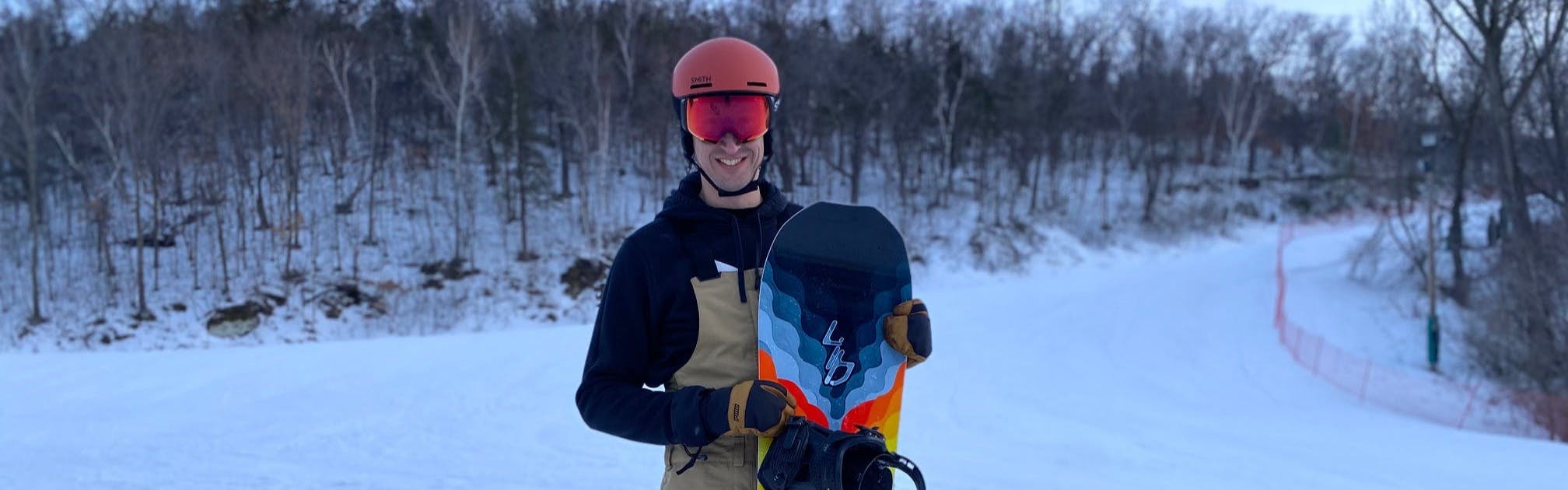 Man stands with a snowboard.