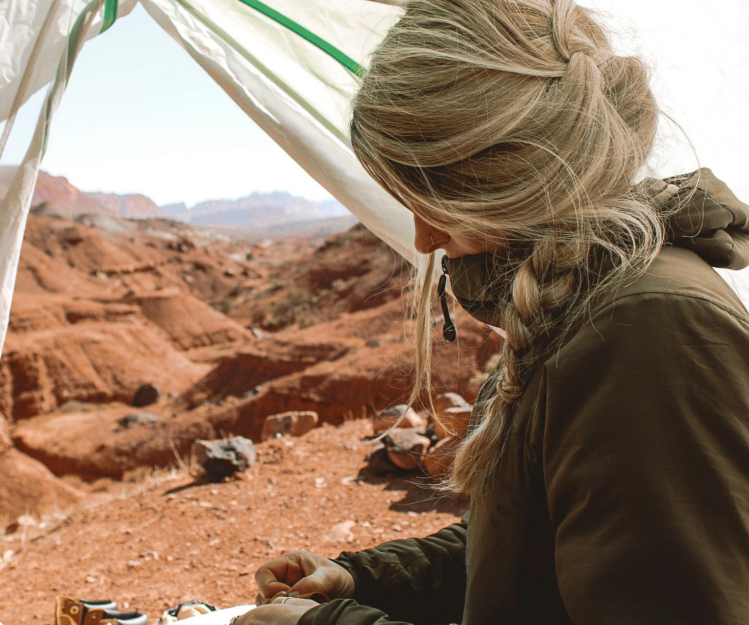A woman in a tent wearing the Arc'teryx Atom LT Jacket.