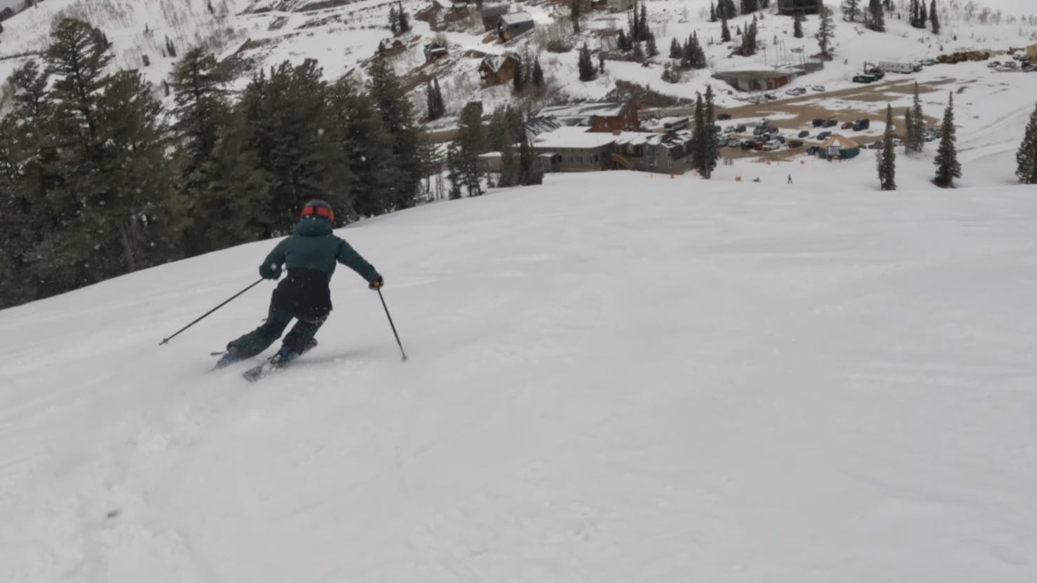 A skier turning down a snowy trail. 