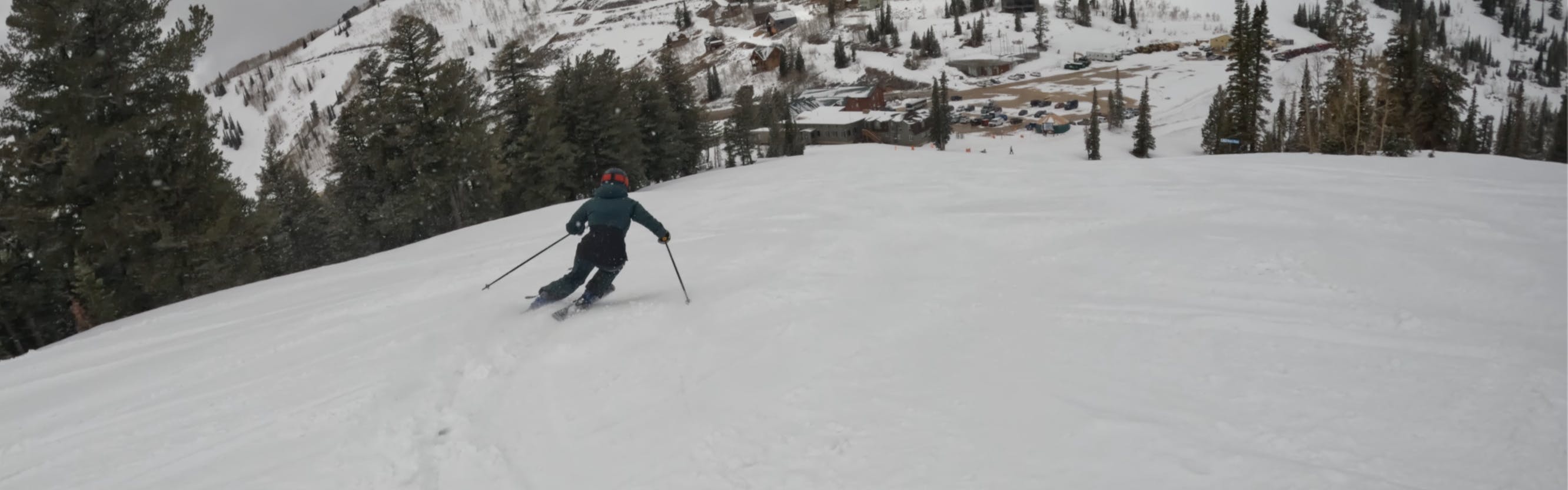 A skier turning down a snowy trail. 