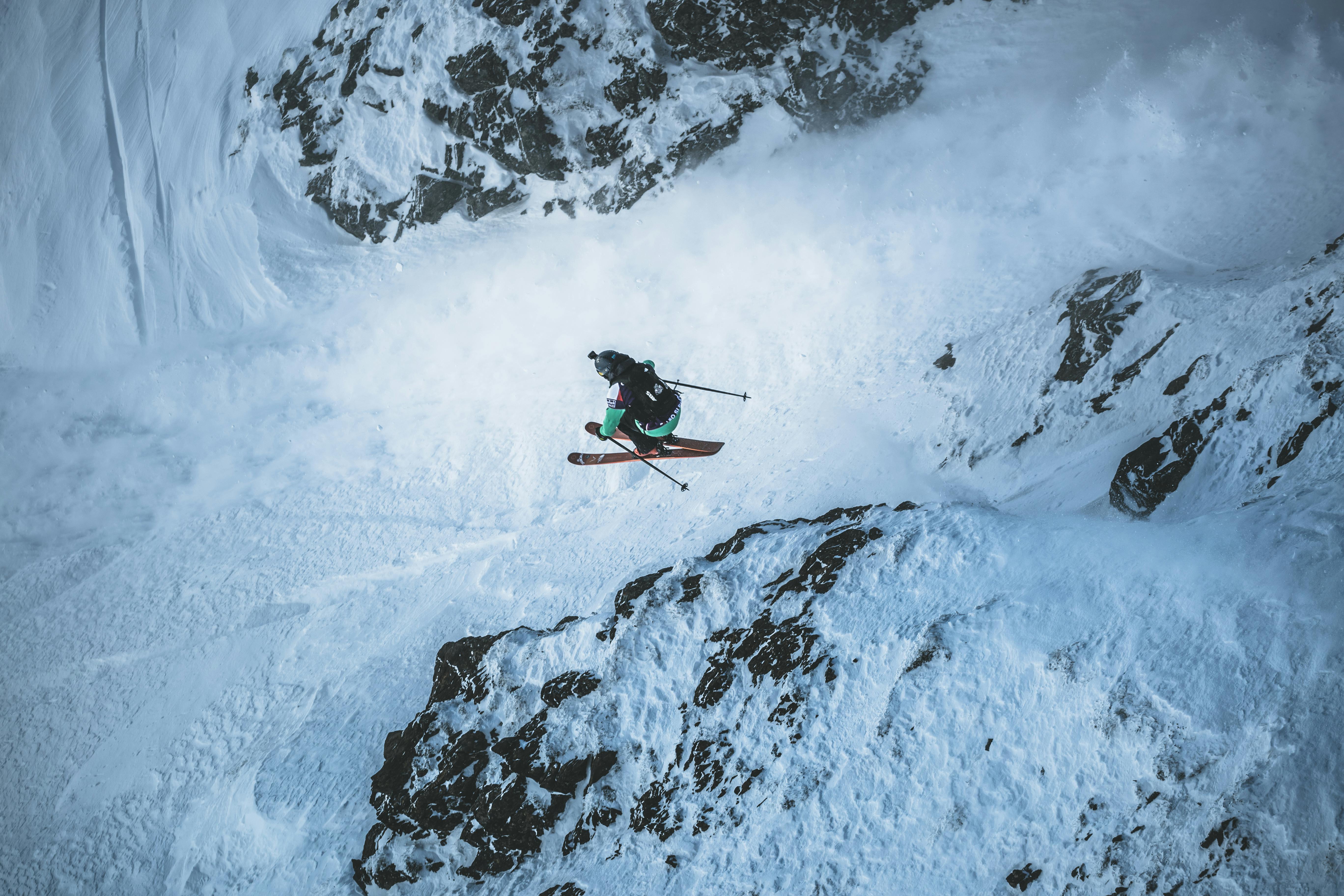 A female skier on the Tour jumps and tucks her knees into her chest. 