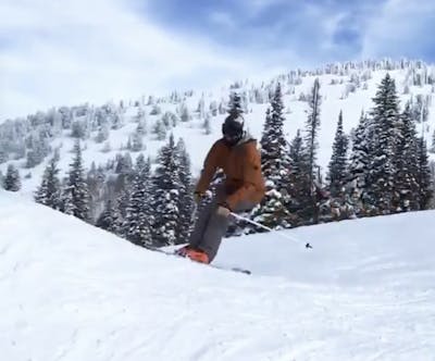 Skier skis backwards down a hill.