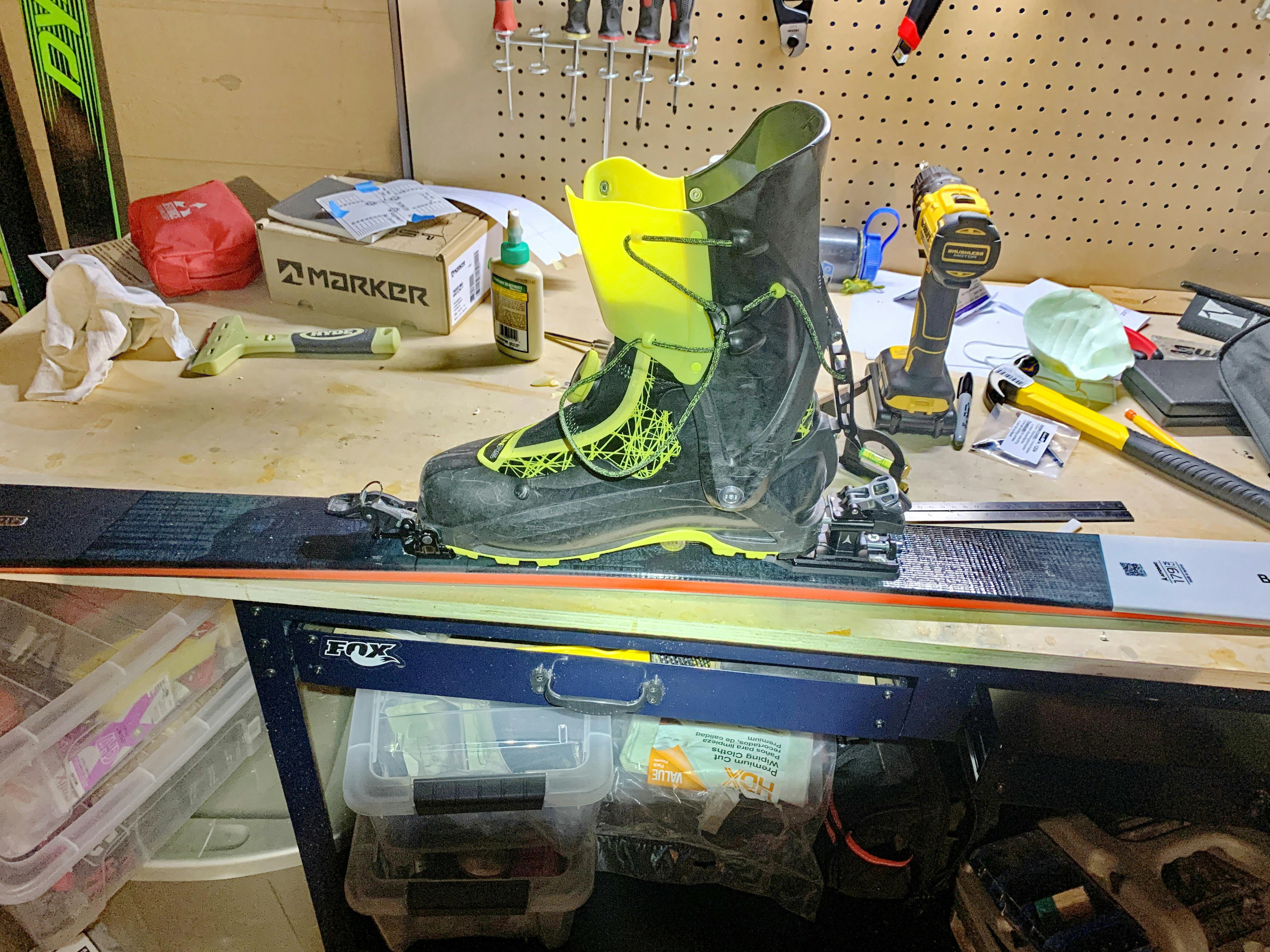 A ski binding being mounted on a ski. 