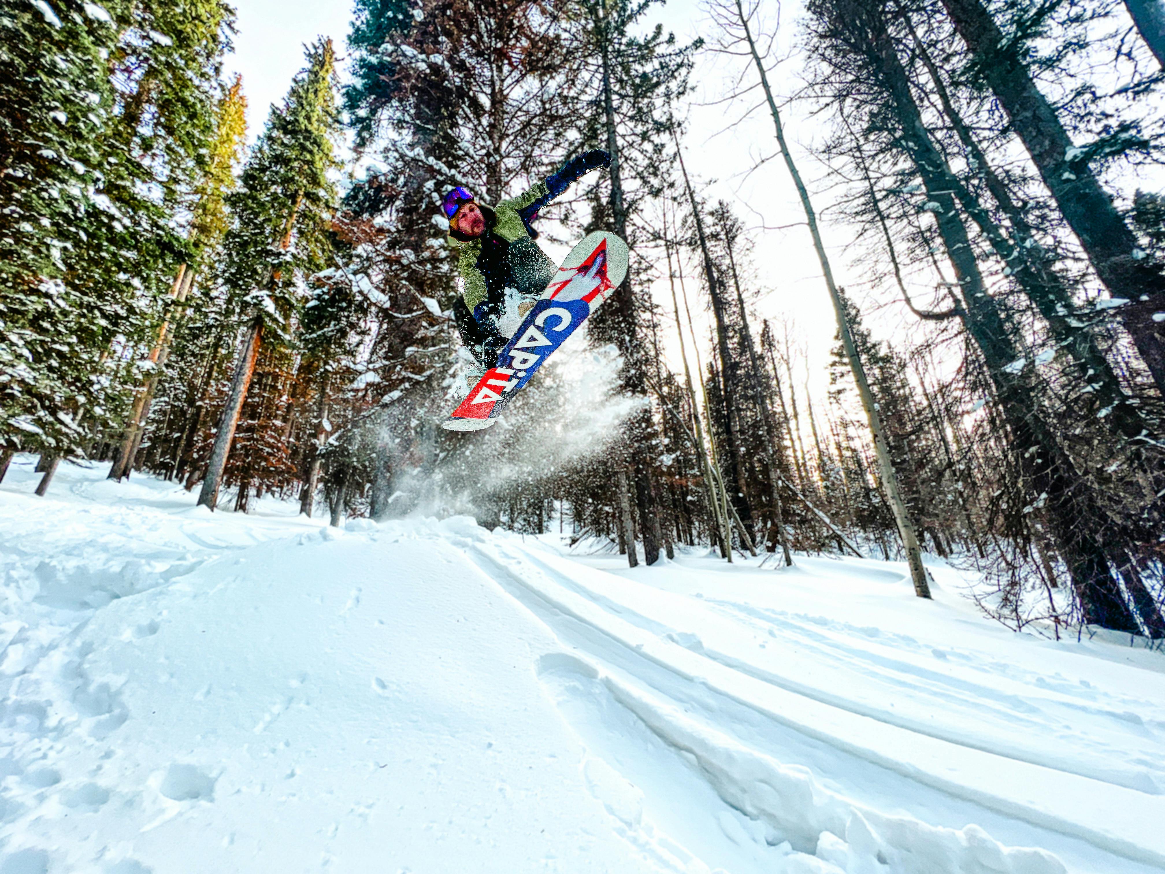 A snowboarder going off a jump in the Burton Moto BOA Snowboard Boots · 2021. 