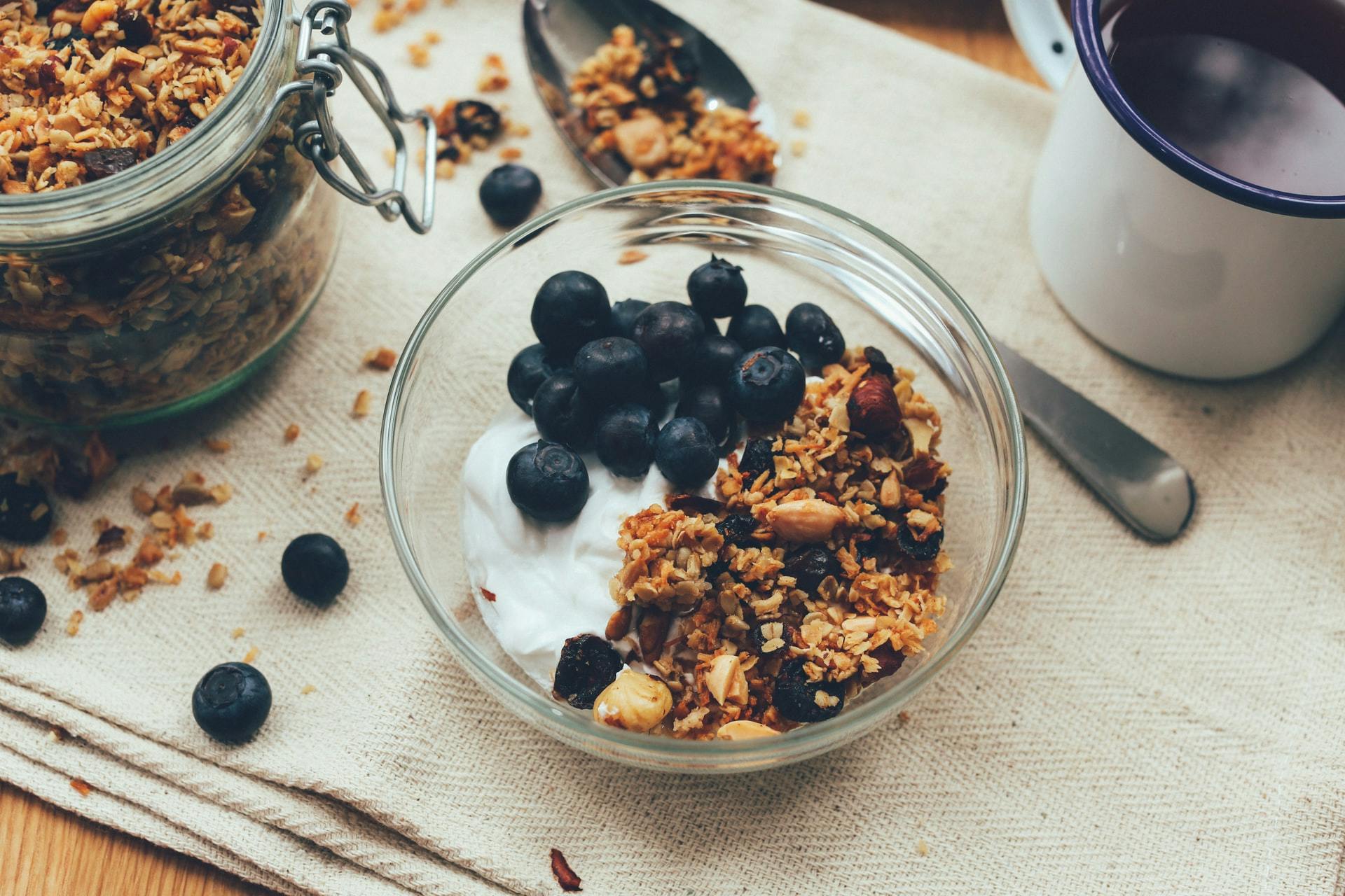 A bowl of yogurt and blueberries and granola.