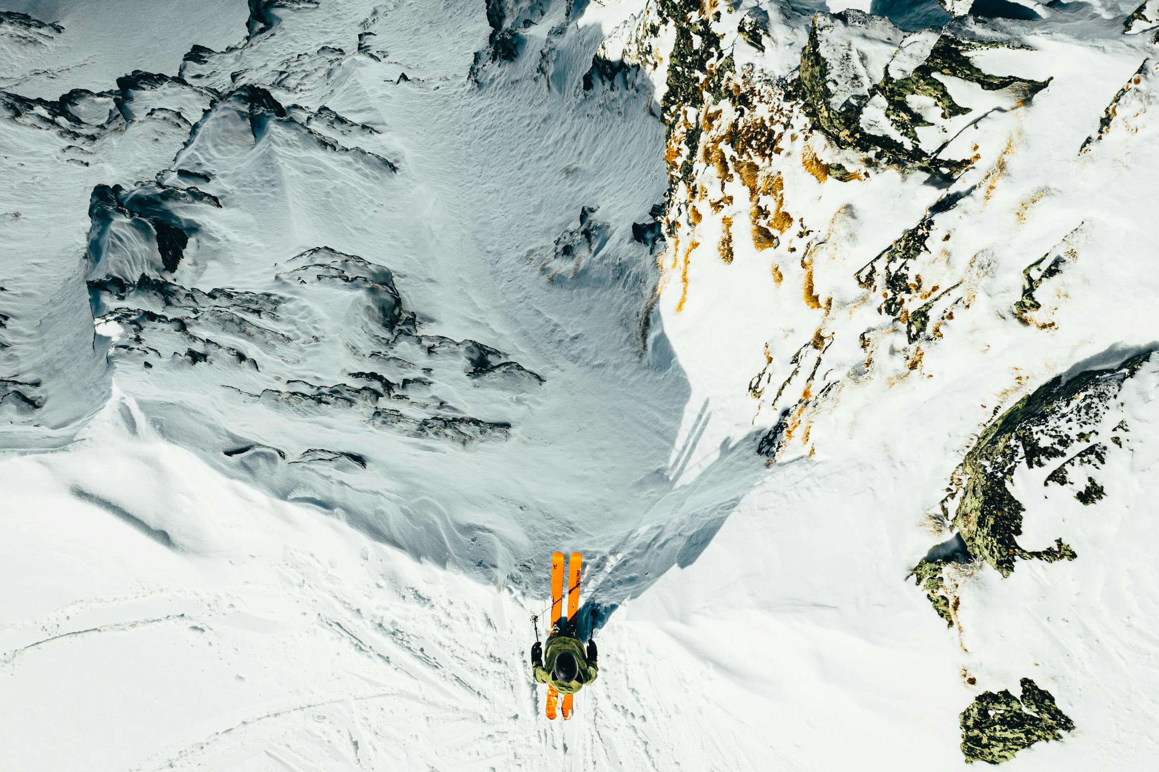 A skier on the edge of a snowy precipice