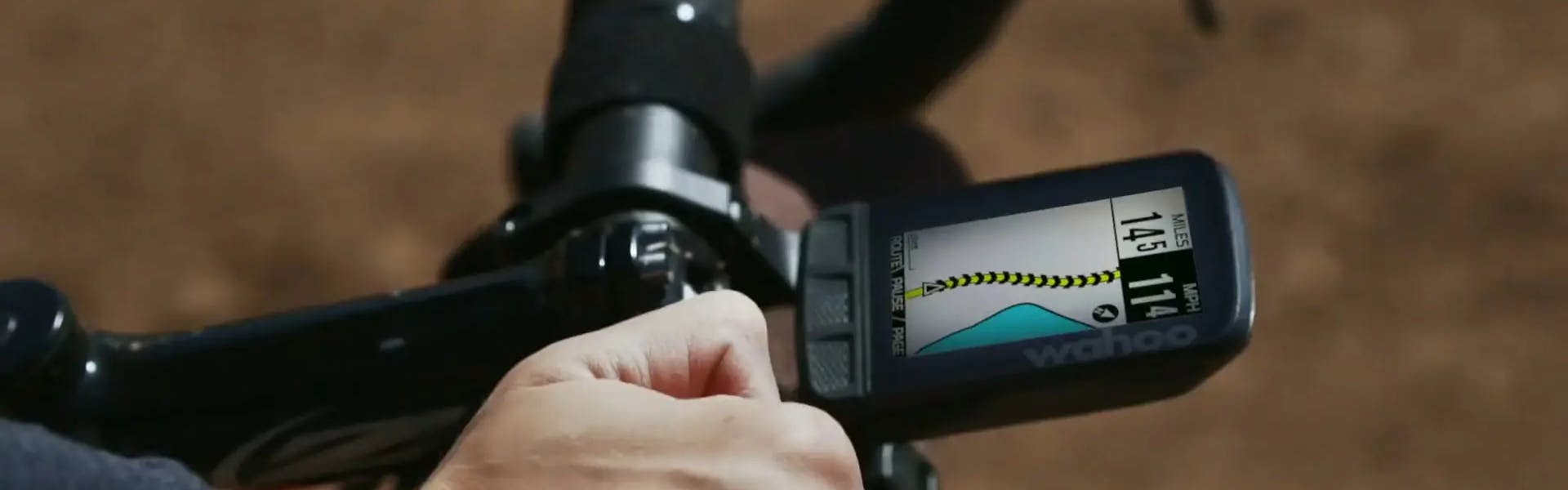 A cyclist rides with a Wahoo Elemnt bike computer on their handlebars. 