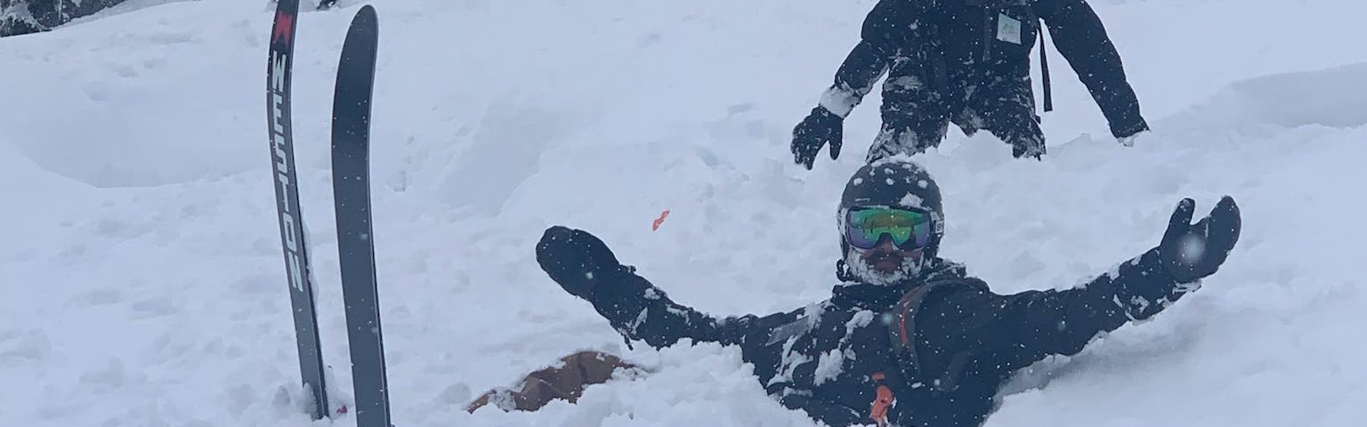 A skier sitting in the snow.