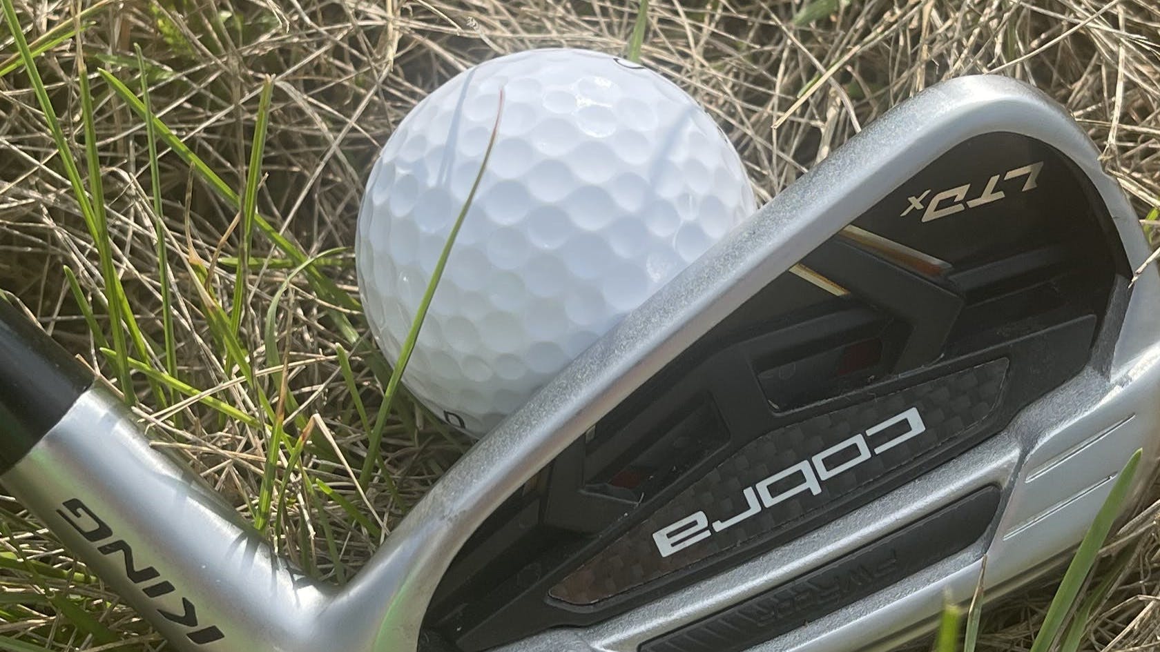 The Cobra LTDx Iron in front of a golf ball.