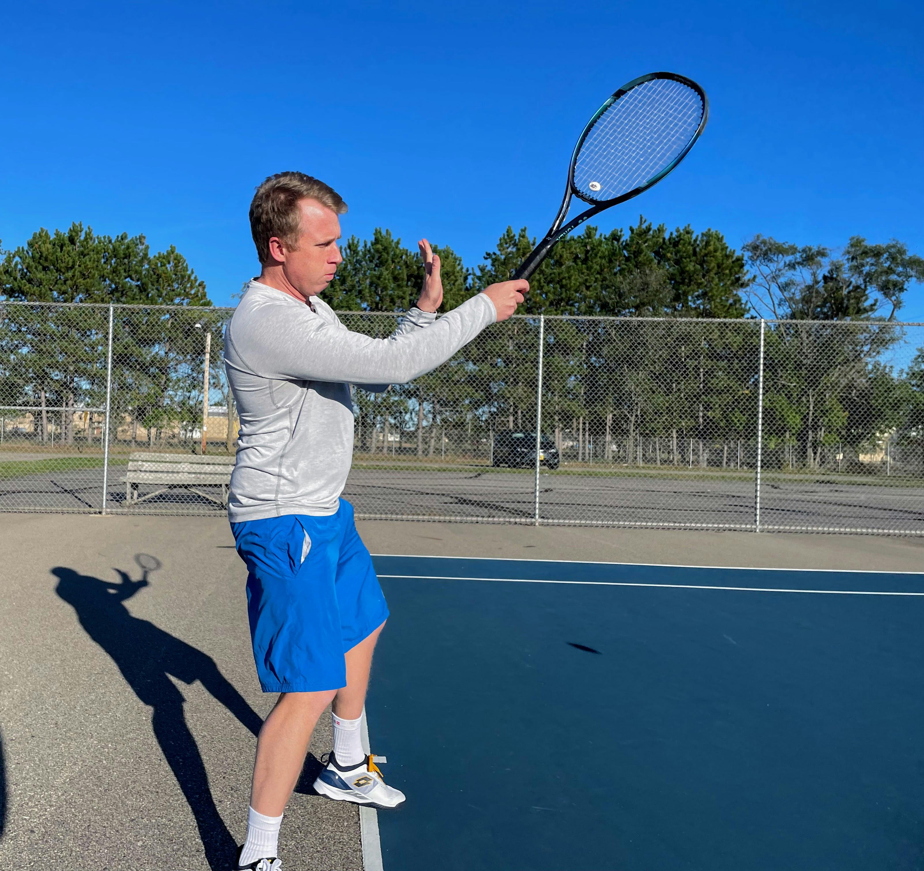 A tennis player using the Yonex EZone 100 Racquet.
