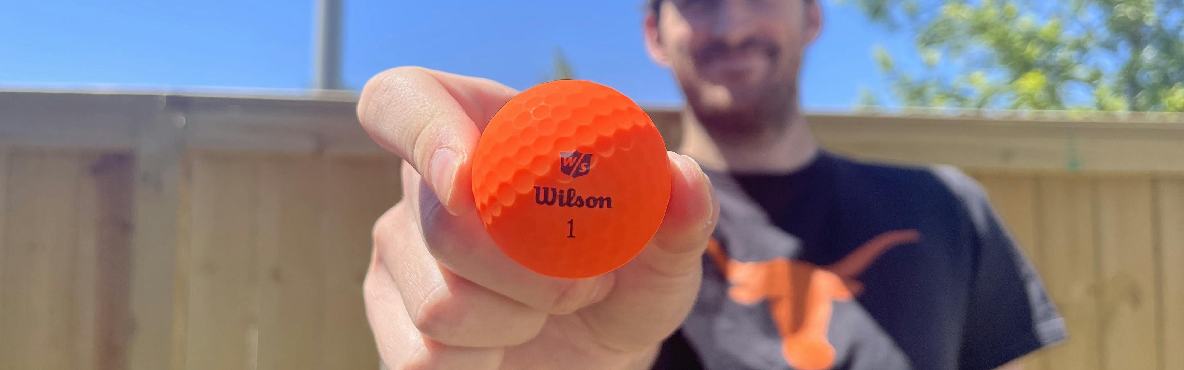 A man holding a Wilson 2022 Duo Soft Optix Golf Ball.