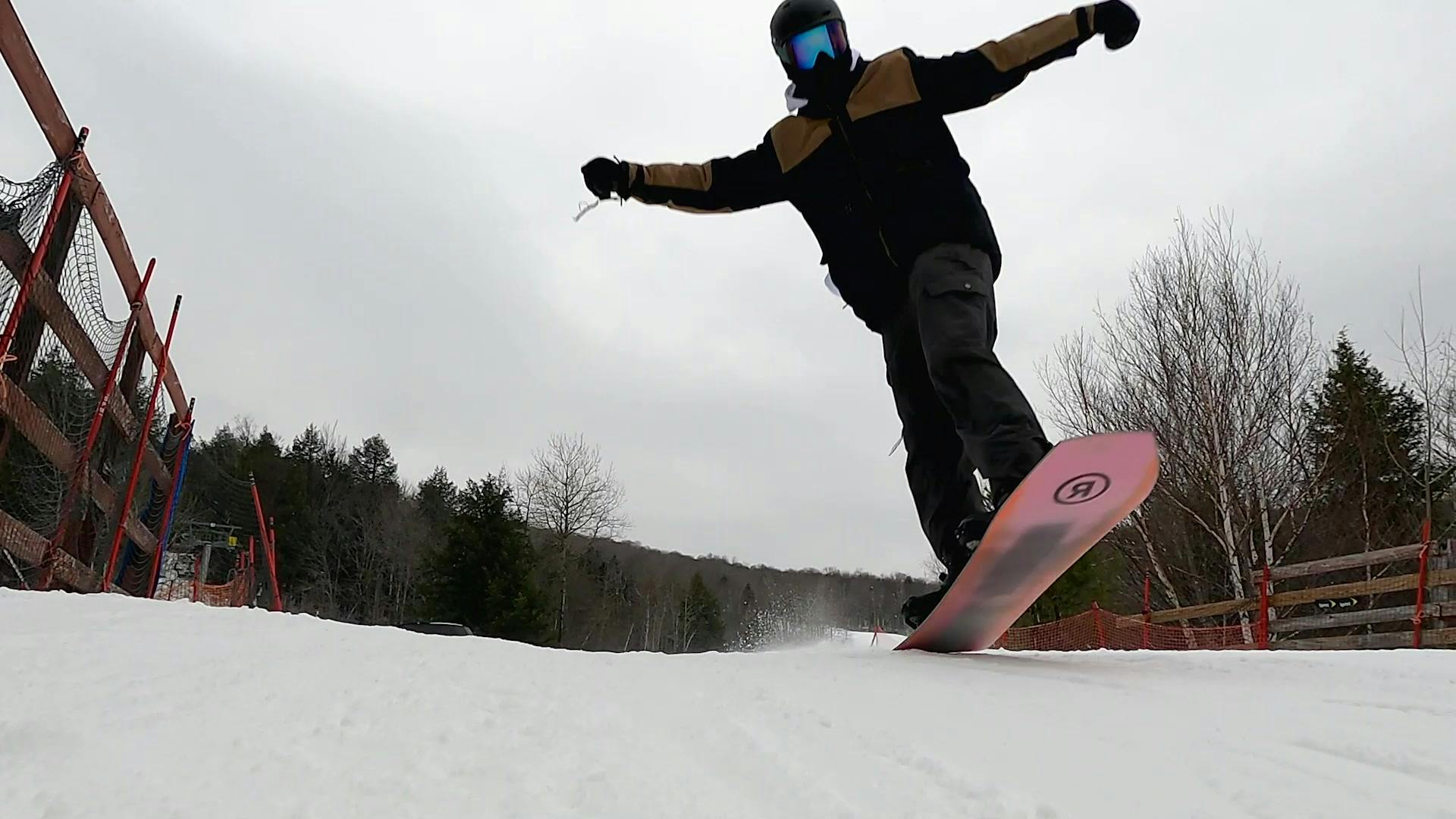 Curated expert Colby starting a jump with his snowboard