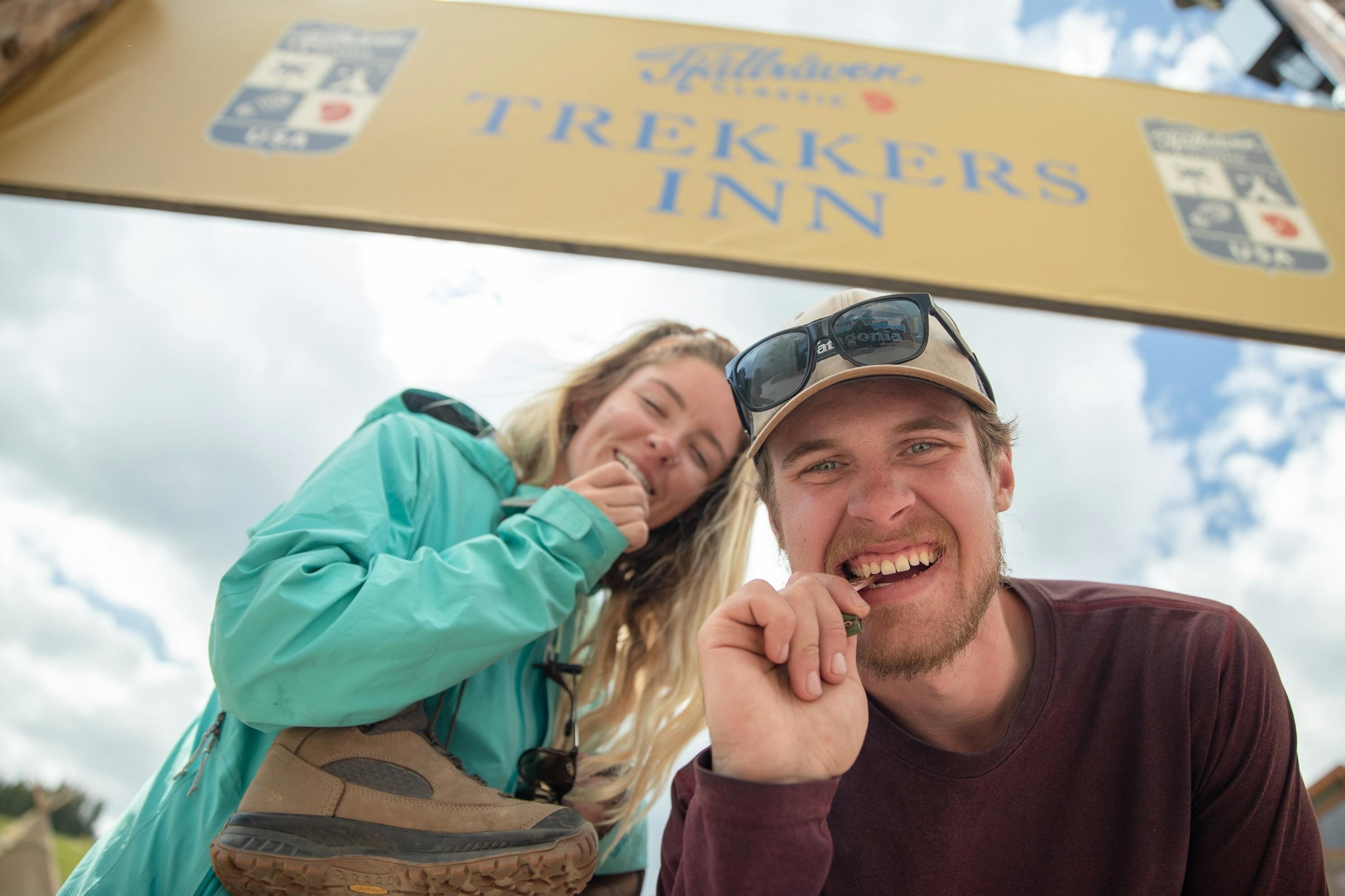 Two people looking at the camera under a sign that reads "trekkers inn".