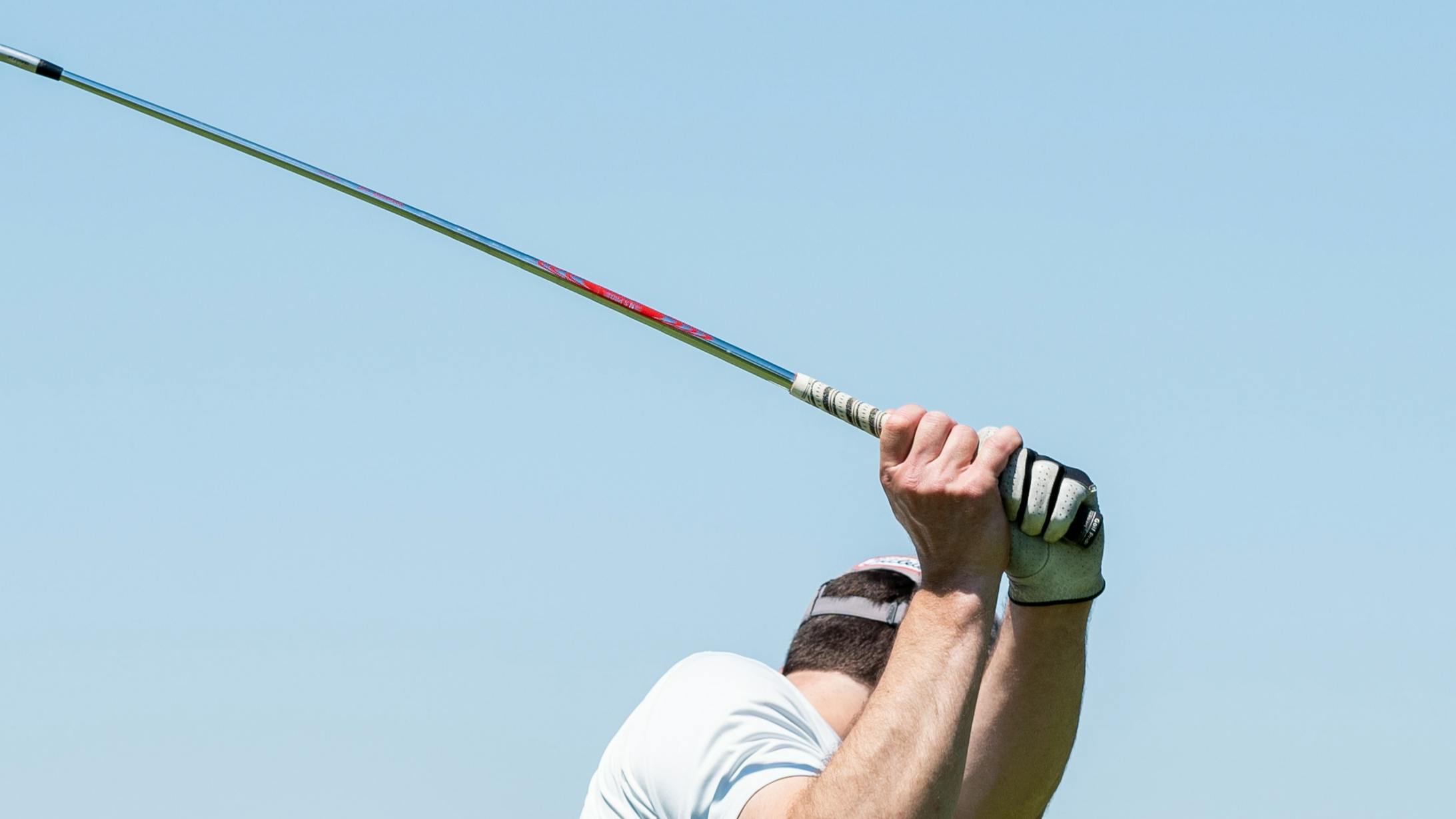 A golfer using an iron. 