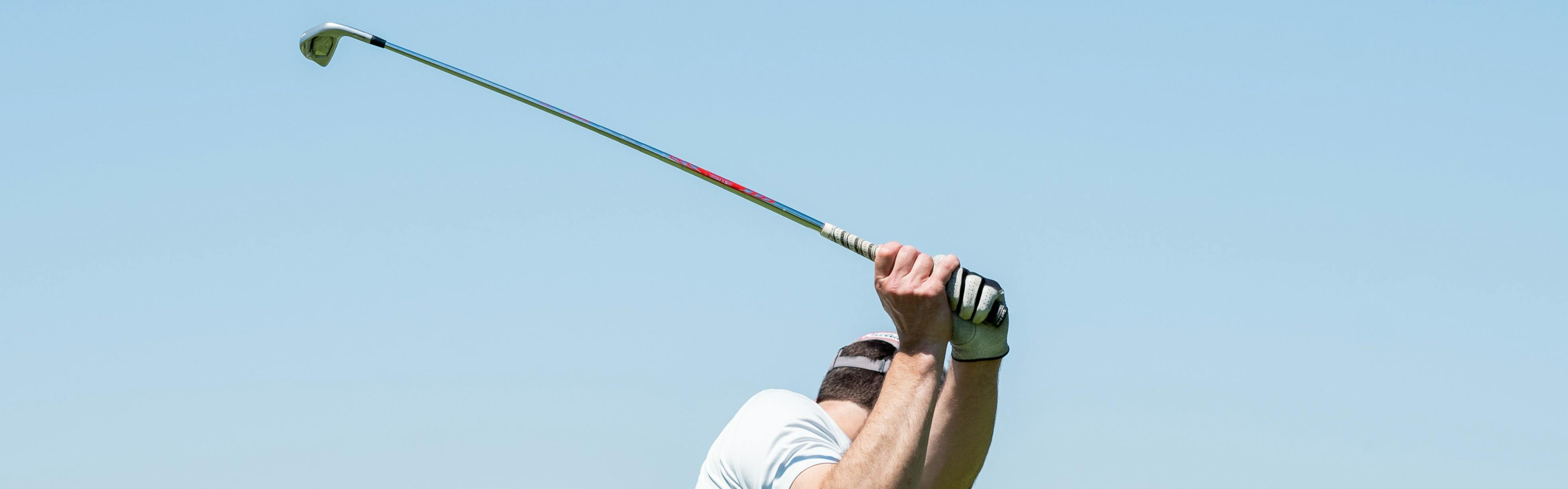 A golfer using an iron. 