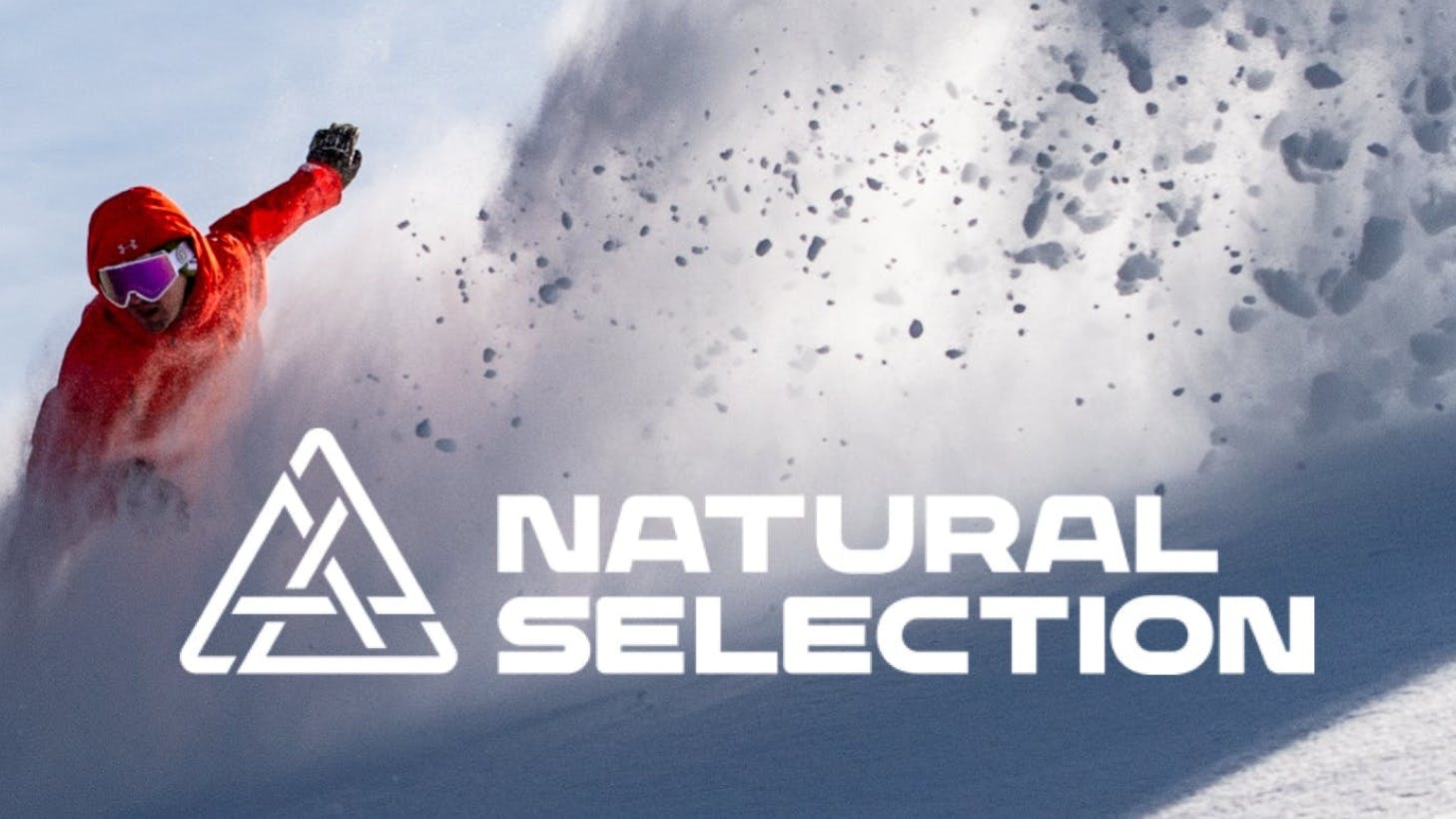 A snowboarder turning down a snowy mountain side with a logo overlaid that reads "Natural Selection".