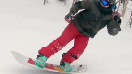 A snowboarder doing a trick on the Salomon Hologram Snowboard Bindings.