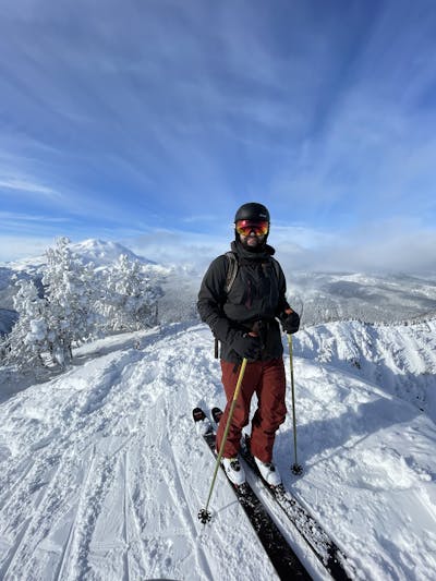 A skier at the top of a snowy ski run. 