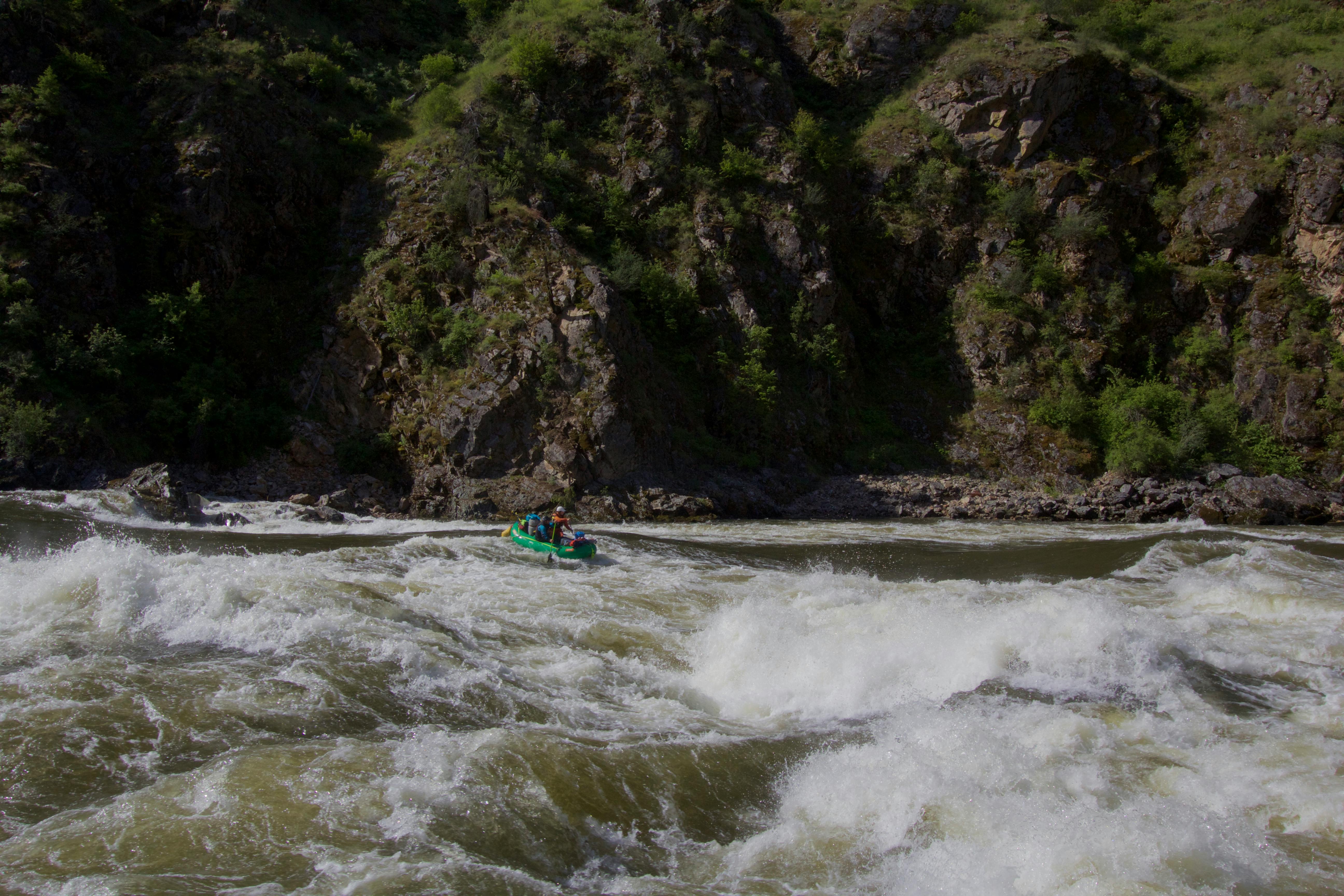 A raft drifts down a stretch of whitewater