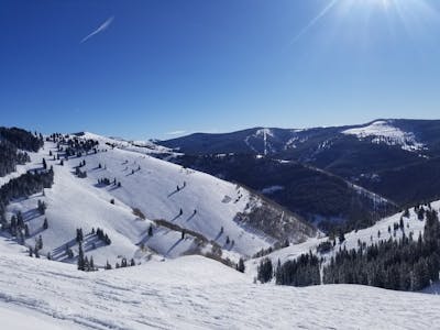 Mountain view of snowy mountains on a ski resort run.