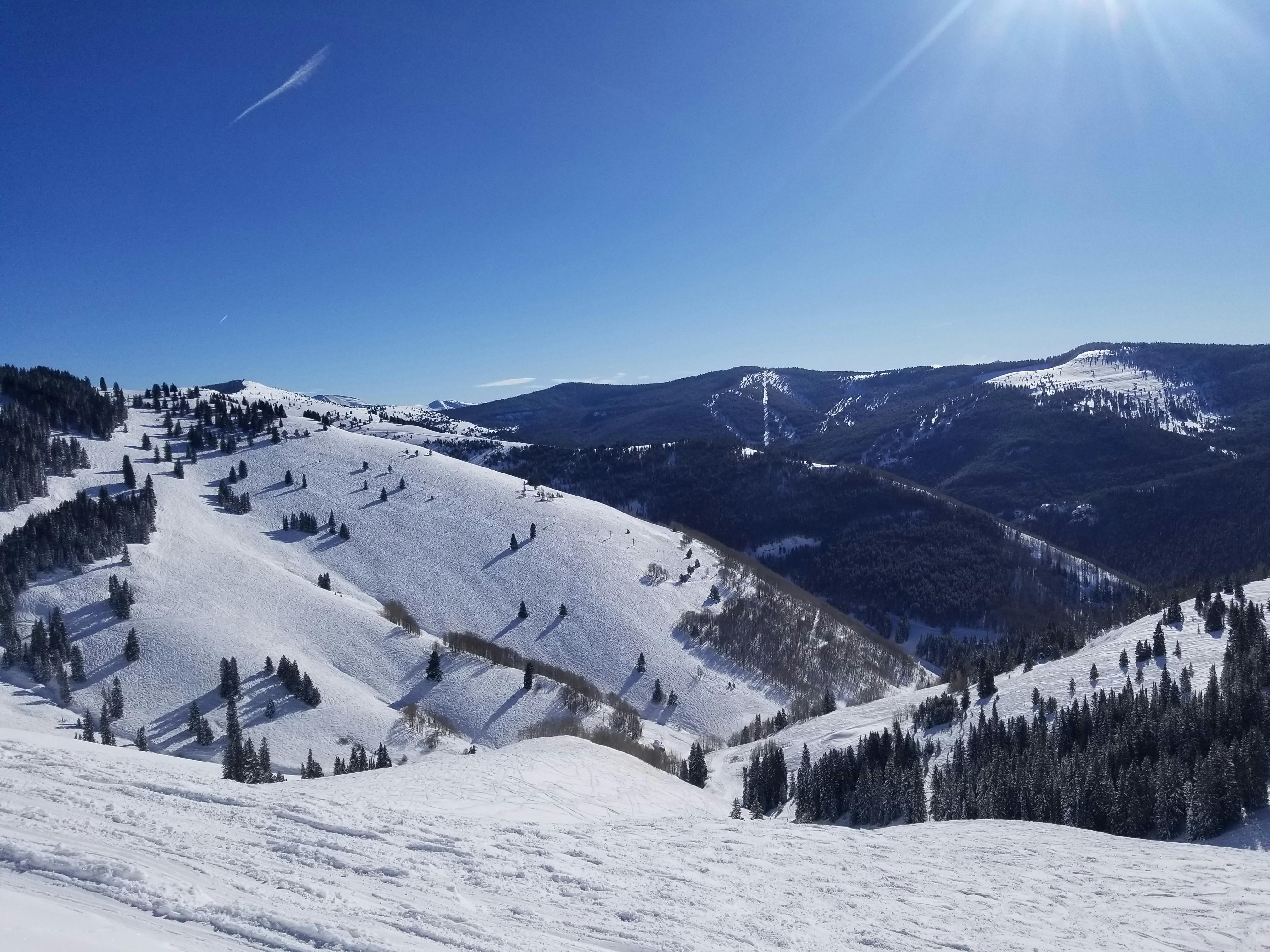 Mountain view of snowy mountains on a ski resort run.