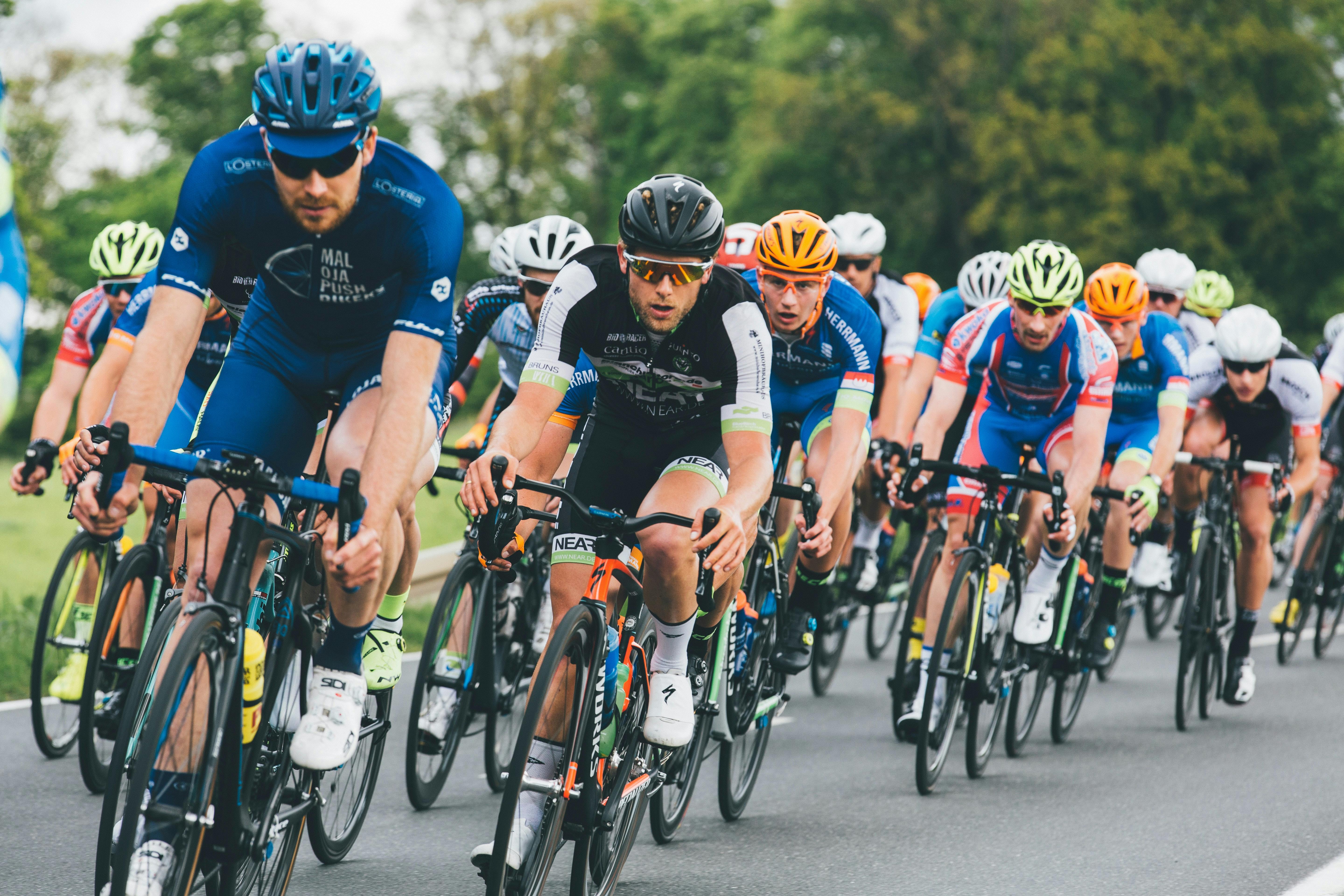A group of road cyclists racing together in a peloton.