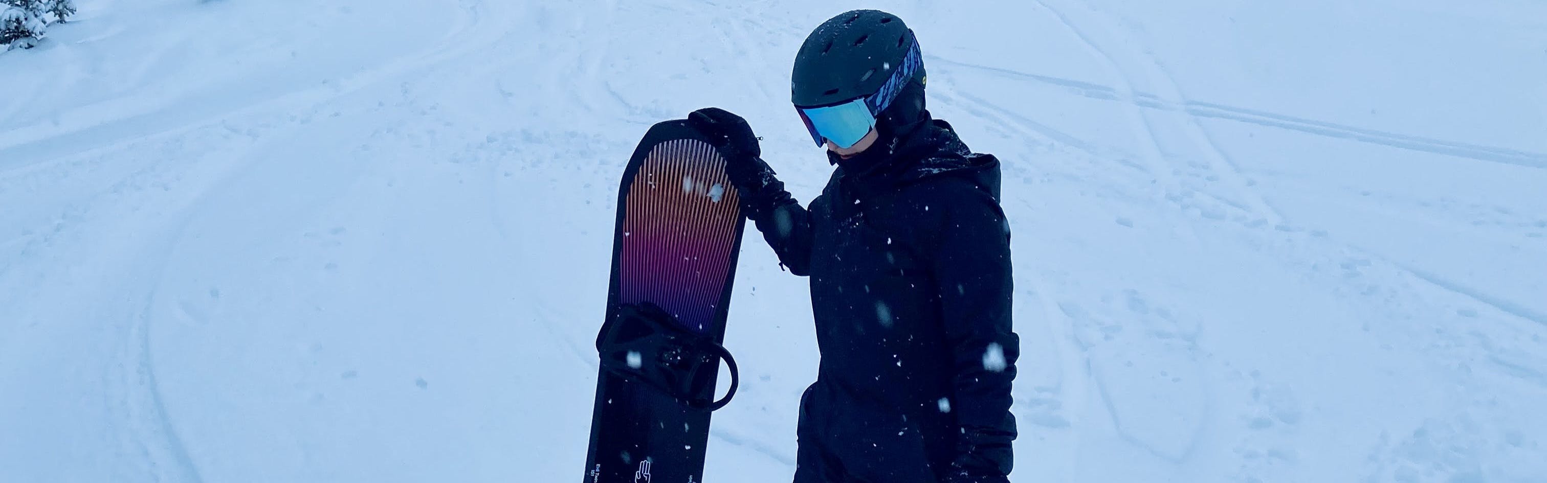 A woman holding the Bataleon Evil Twin Snowboard. 
