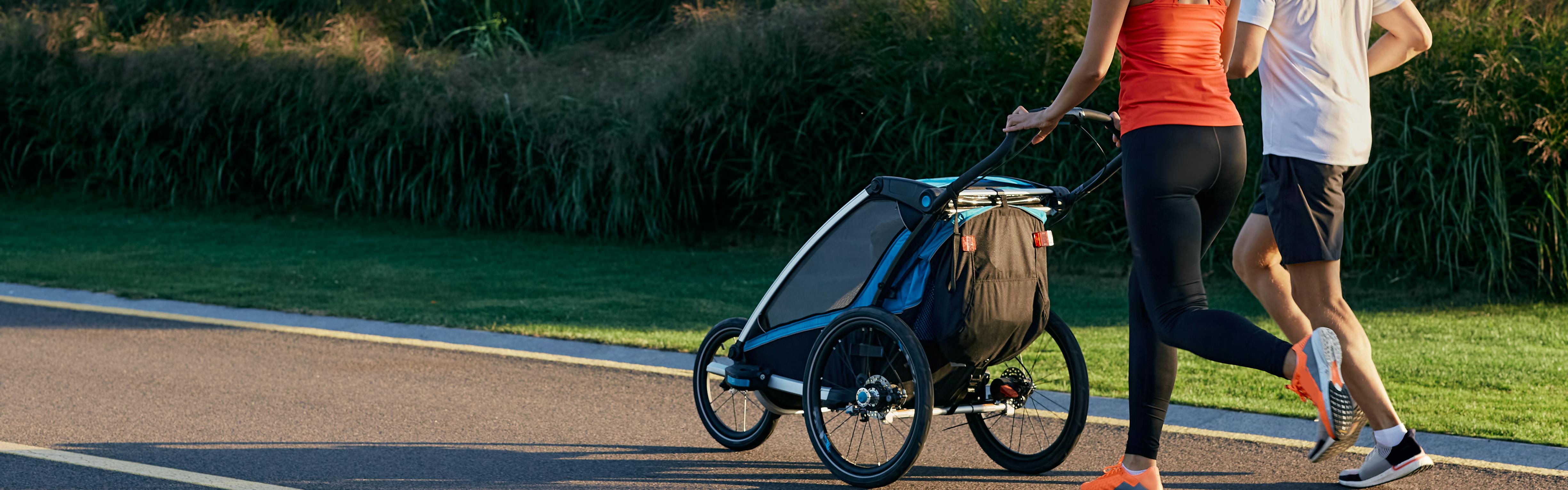 Two people walking with a baby in stroller