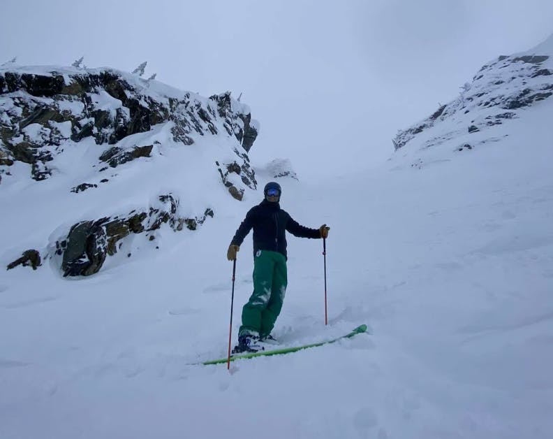A skier standing on a snowy trail. 