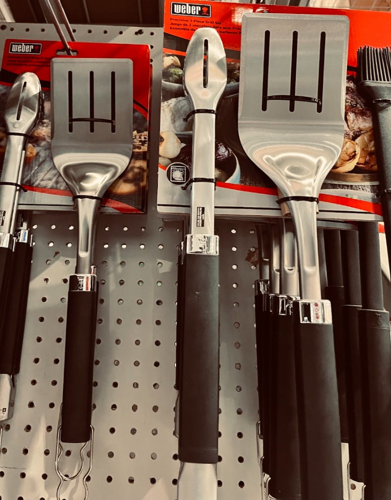 Weber Grill accessories including tongs, a basting brush, and a spatula. 