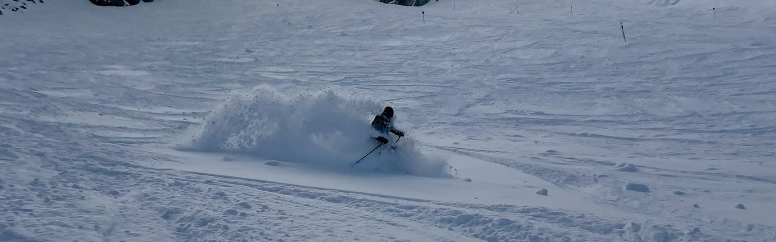 A skier turning down a snowy run. 