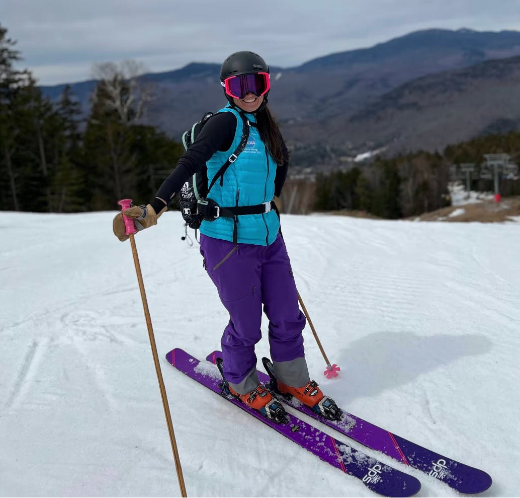 A woman smiling at the camera on a ski run. She is skiing on the DPS Pagoda 106 C2 Skis · 2022. 