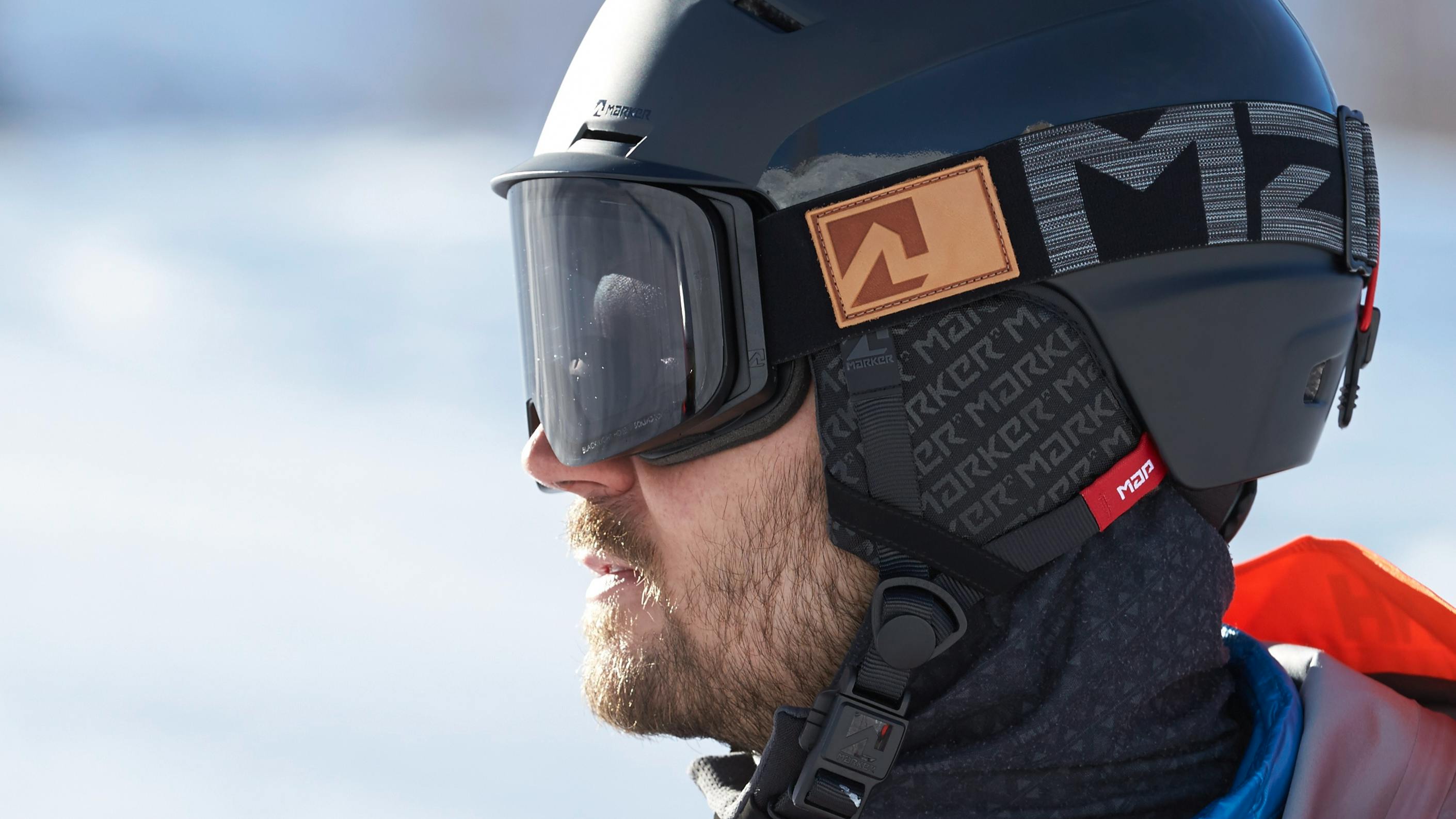 Closeup on a man wearing a black ski helmet and black ski goggles